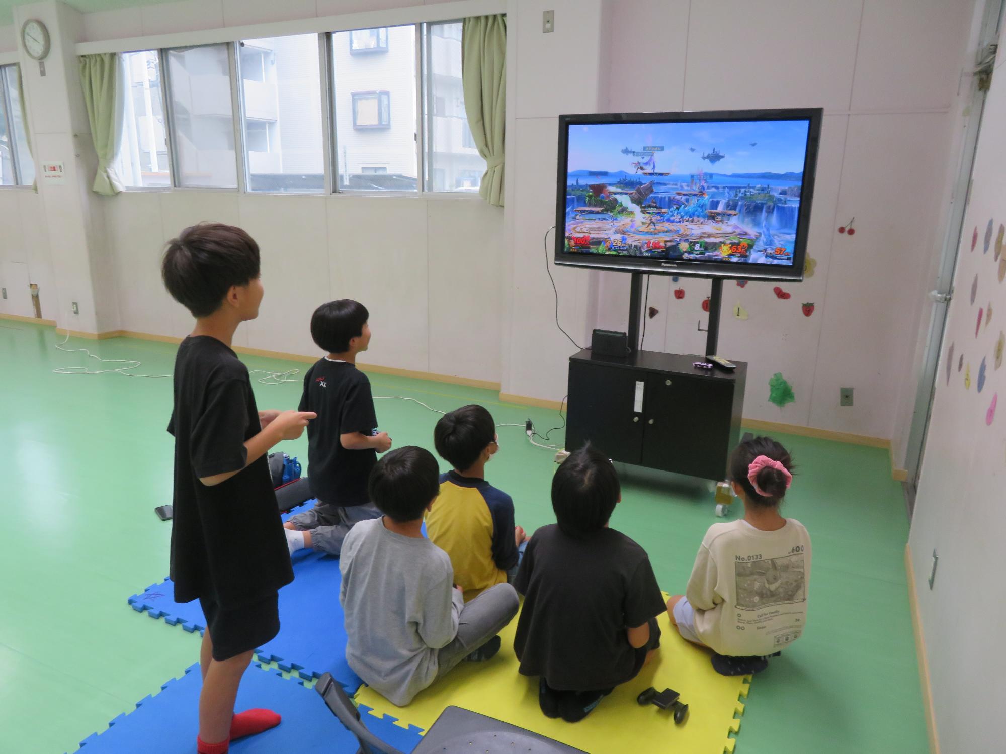 テレビゲームで遊ぶ小学生児童の様子の写真