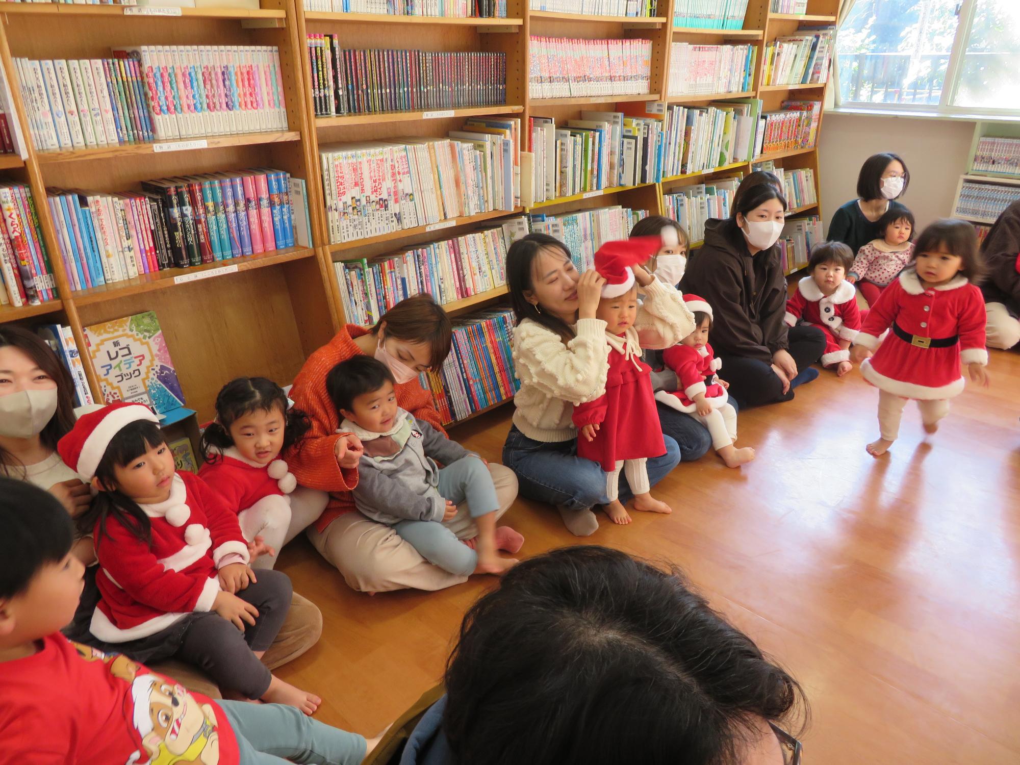 絵本の読み聞かせを聞いている乳幼児親子の様子の写真