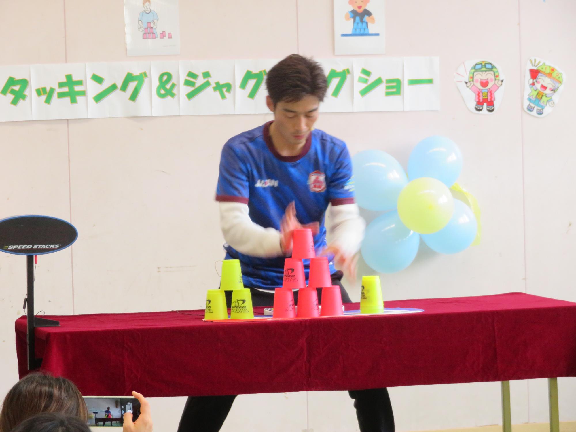 講師によるスポーツスタッキングの技の披露の様子の写真