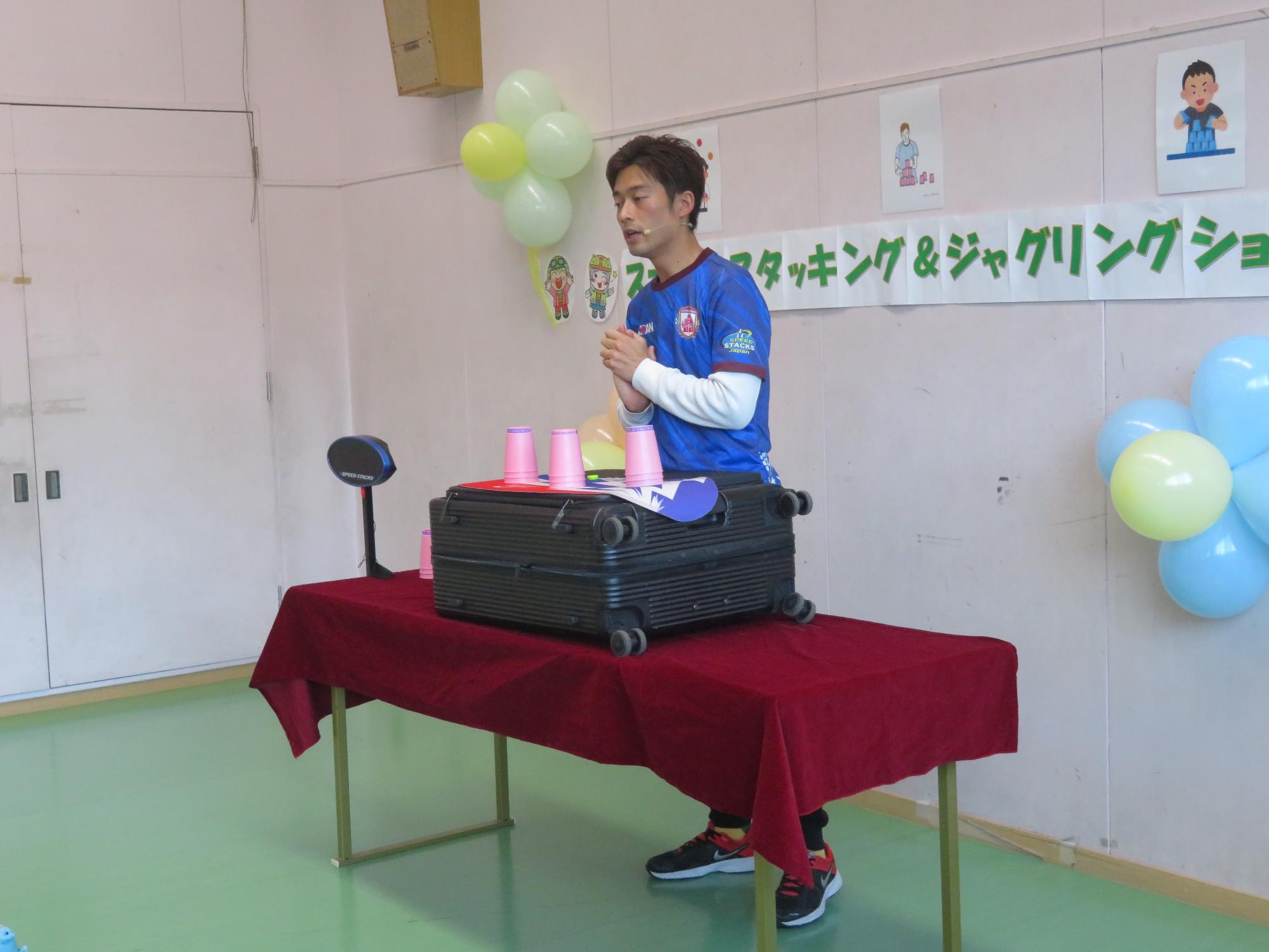 講師が参加者に向けてスポーツスタッキングの説明をしている様子の写真