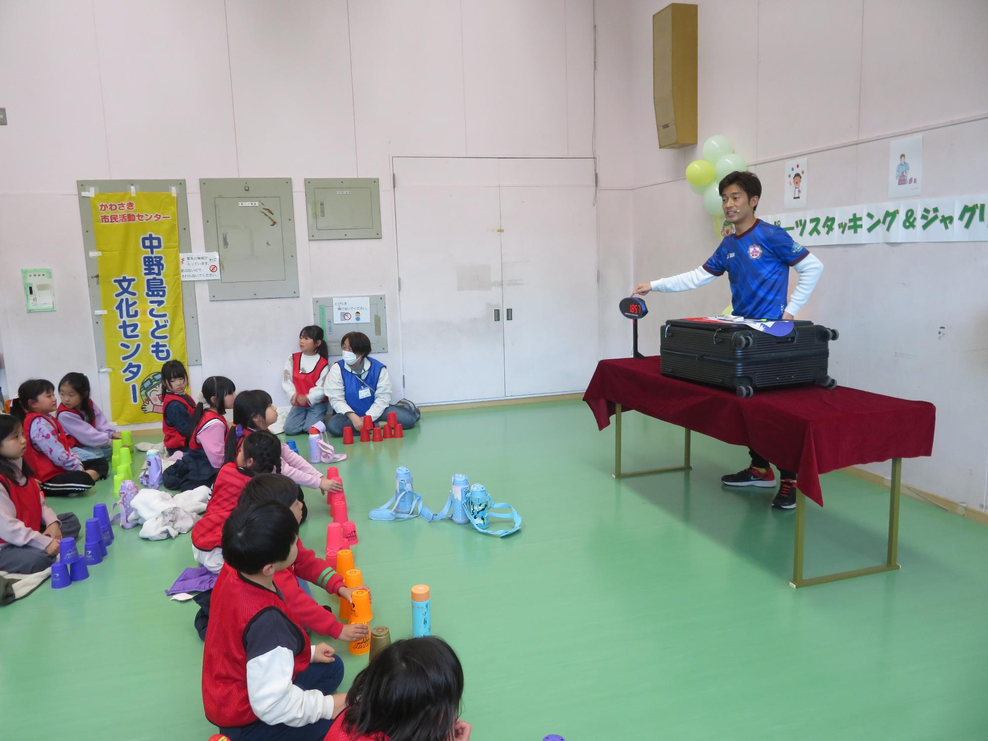 講師の指導のもとスポーツスタッキングのタイムアタックに挑戦する参加児童の様子の写真