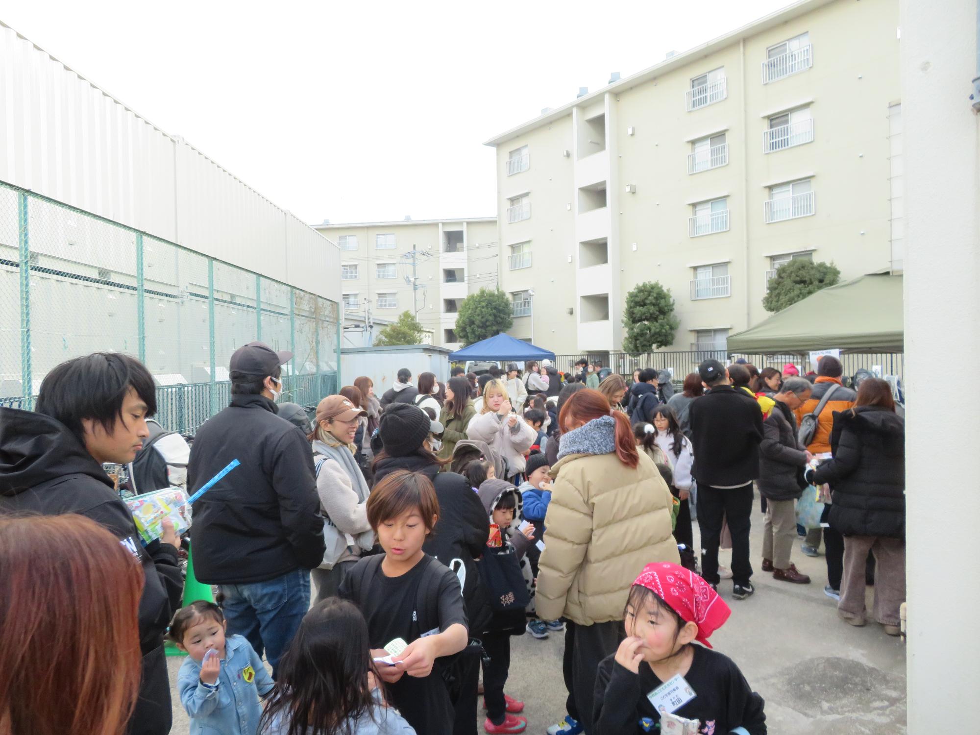 たくさんの参加者がおせんべいやきに列を作って待っている様子の写真