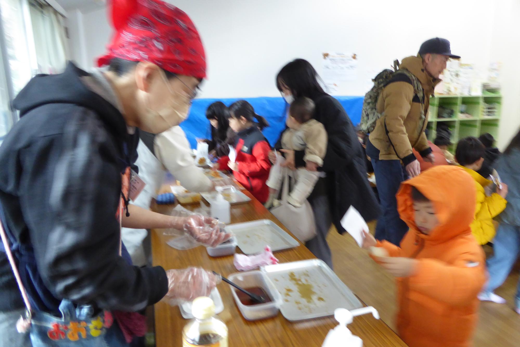 味付けコーナーにて地域の方と交流する参加者の様子の写真