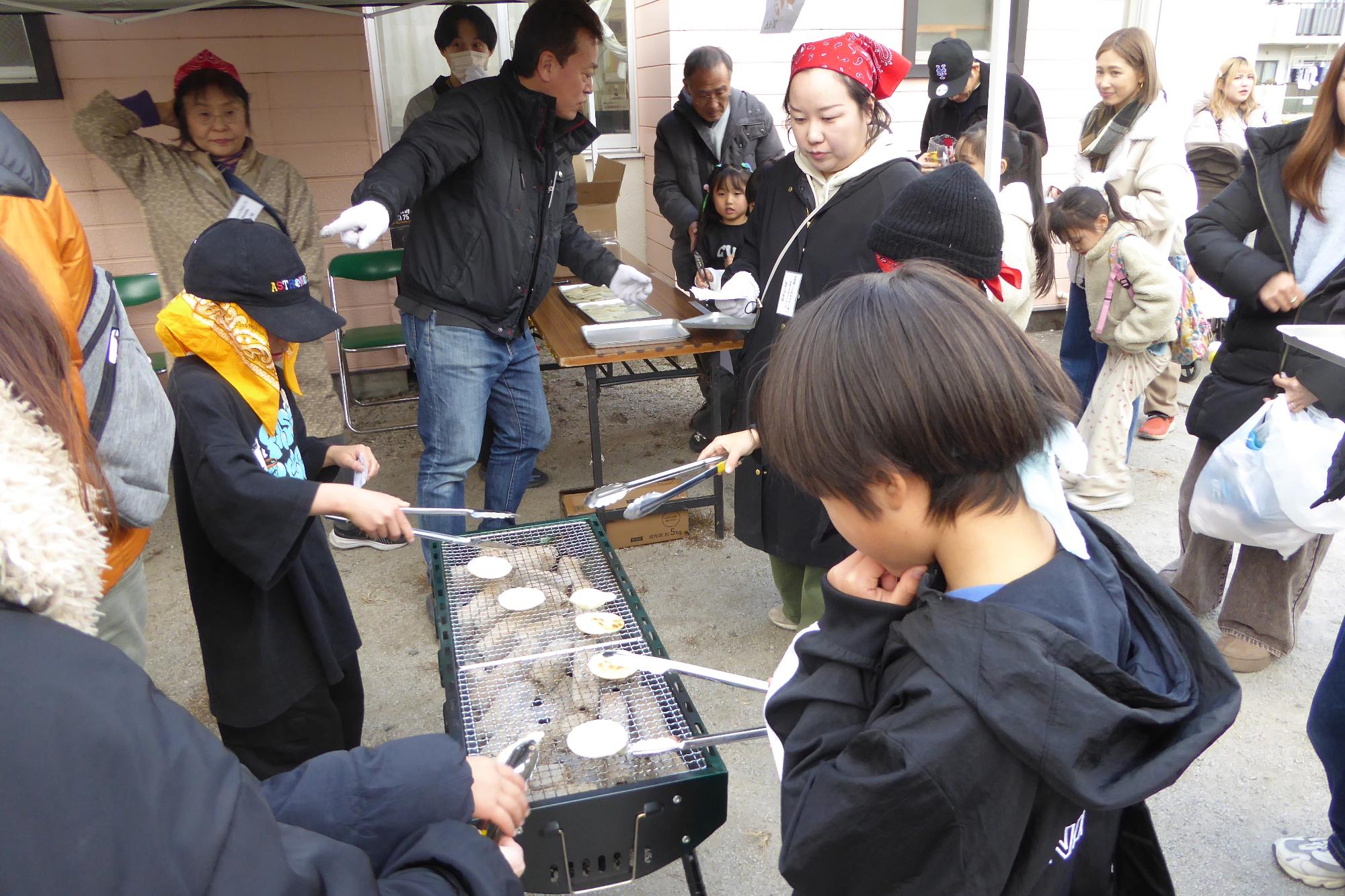 おせんべいやきに挑戦する小学生児童の様子の写真