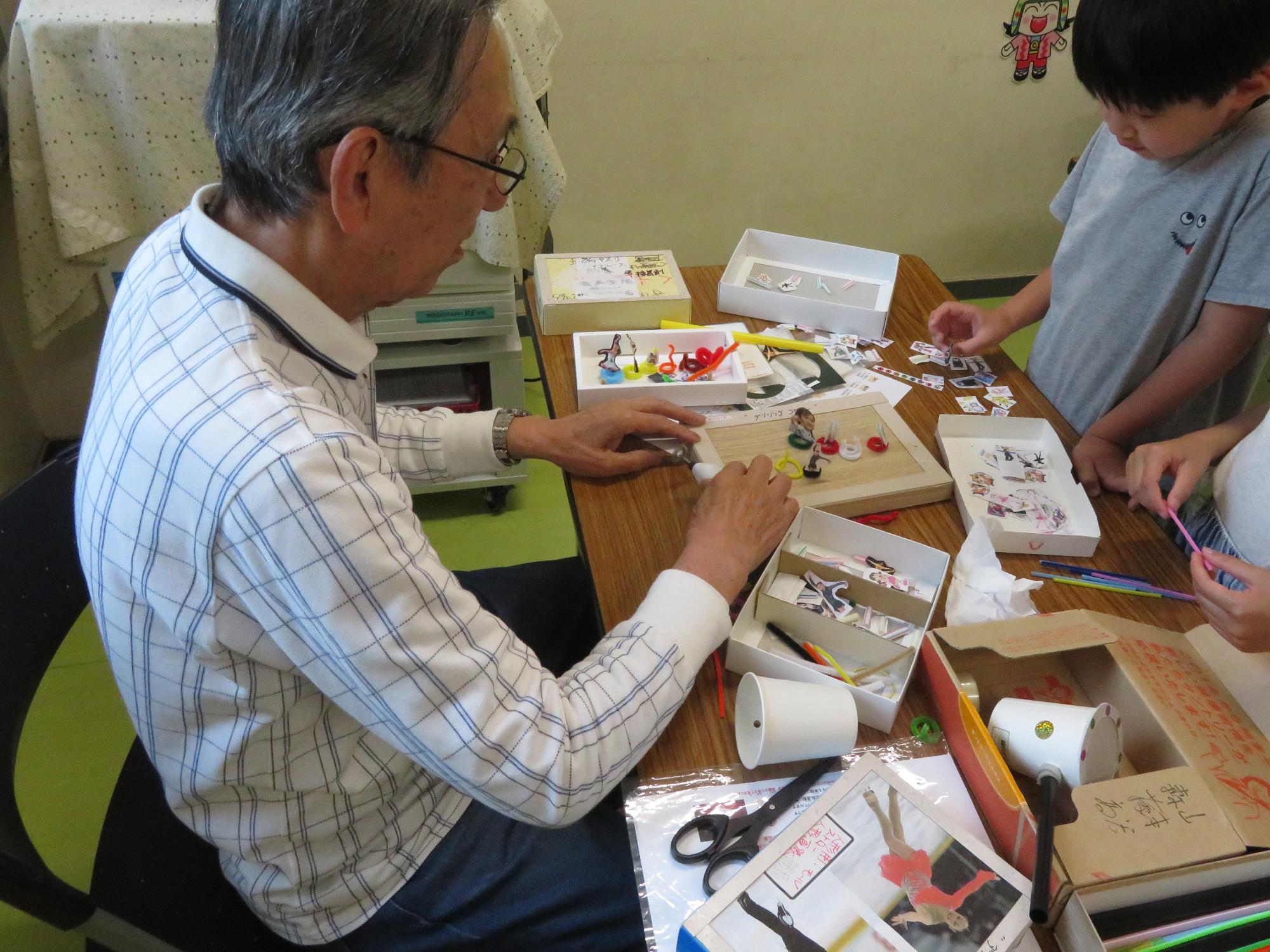 材料を選ぶこどもたちと先生の写真