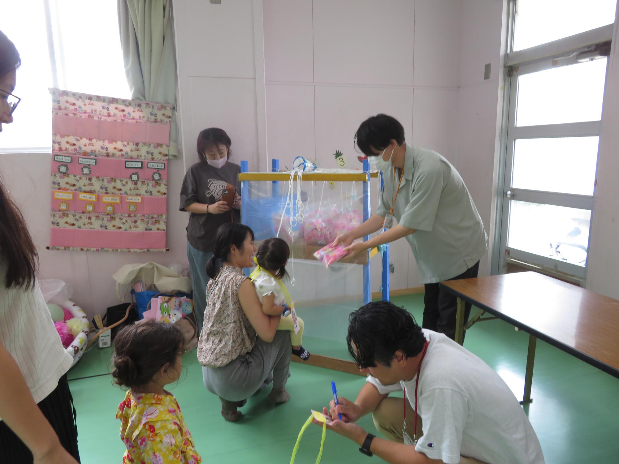 お土産の駄菓子くじを引くこどもの写真