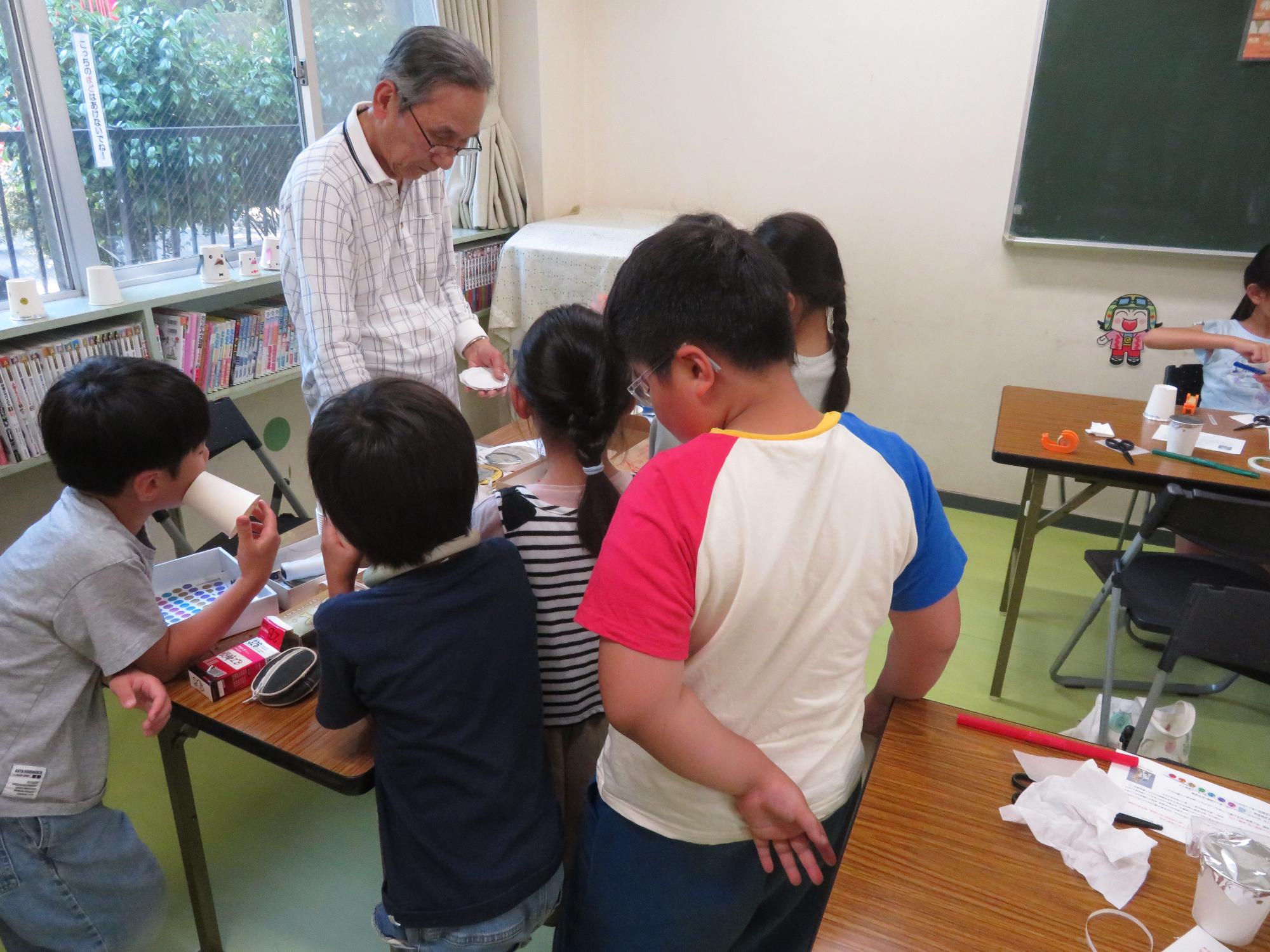 実験の説明を聞くこどもたちの写真