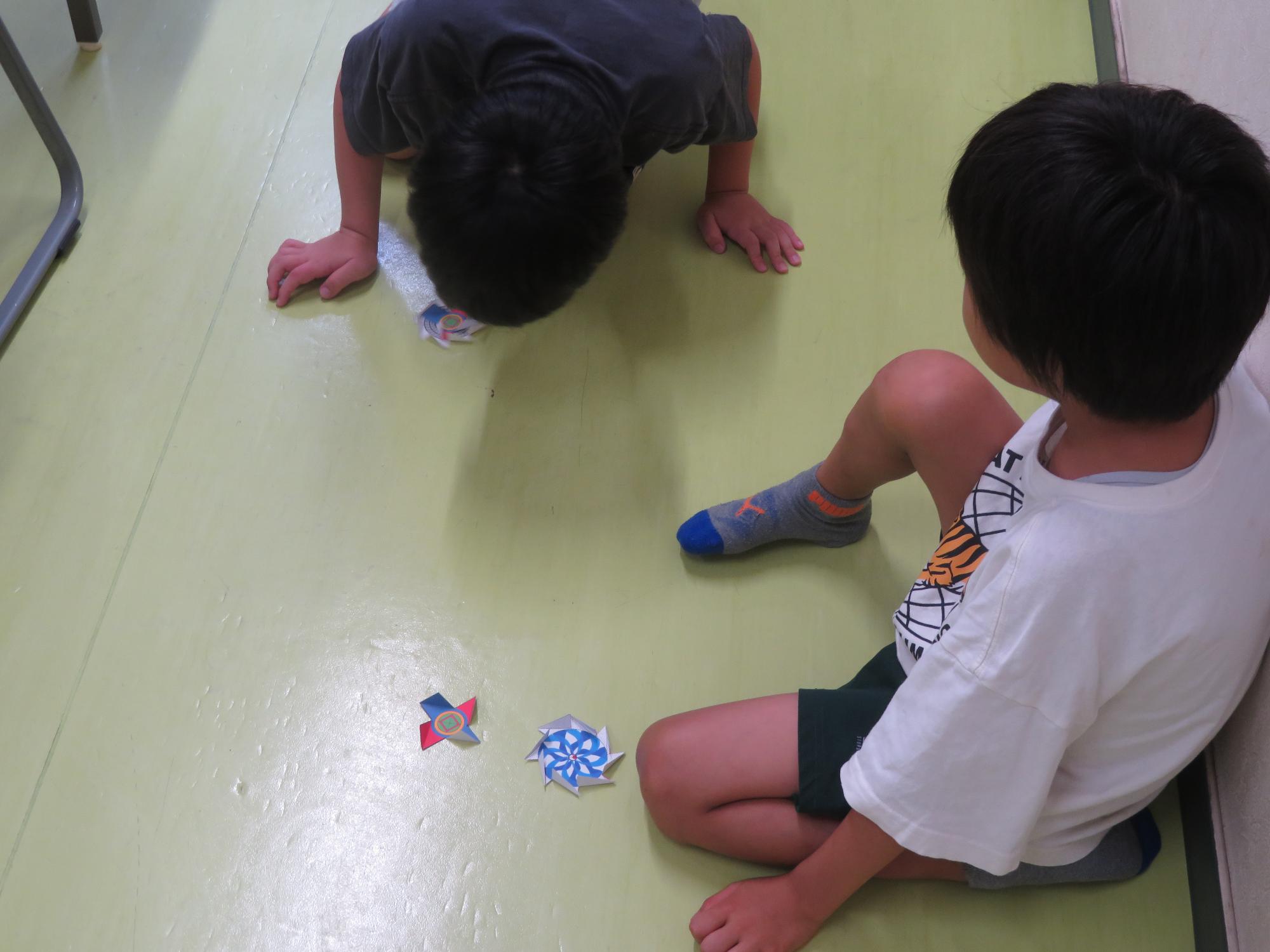 作ったコマで遊ぶ子どもたちの写真