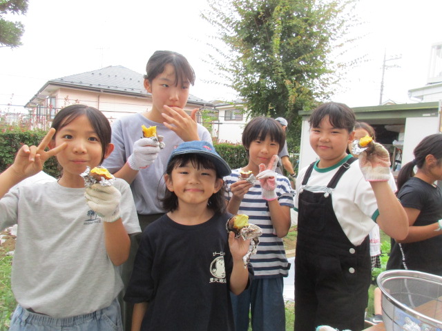 農園クラブ焼き芋を持つこどもたちの写真