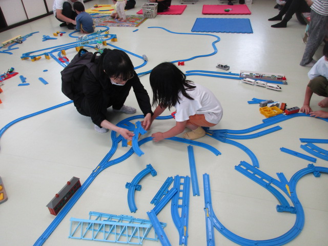 電車おもちゃで遊ぶ親子の写真