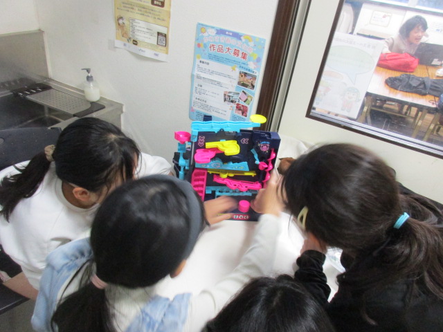 新しいおもちゃで遊んでいる小学生の写真