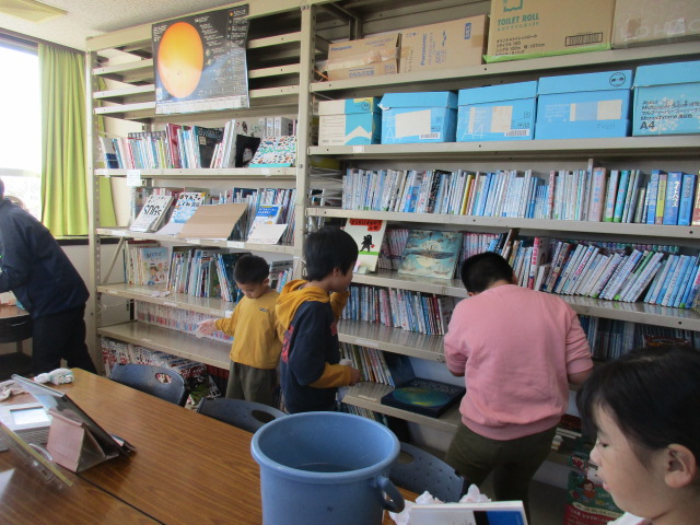 大掃除行事で本をきれいに拭いている写真