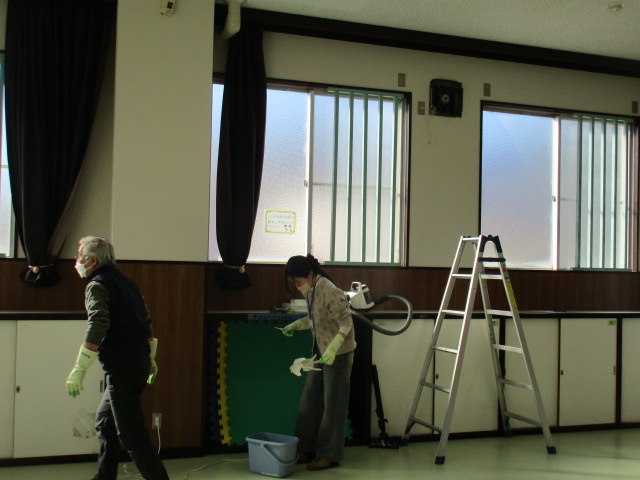 職員が集会室を掃除している写真