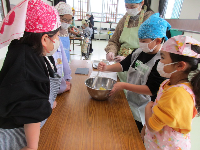 カップケーキの生地をみんなで混ぜている写真