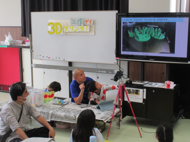 3Dプリンタでパーツが出来上がっていく様子の動画を講師が解説している写真
