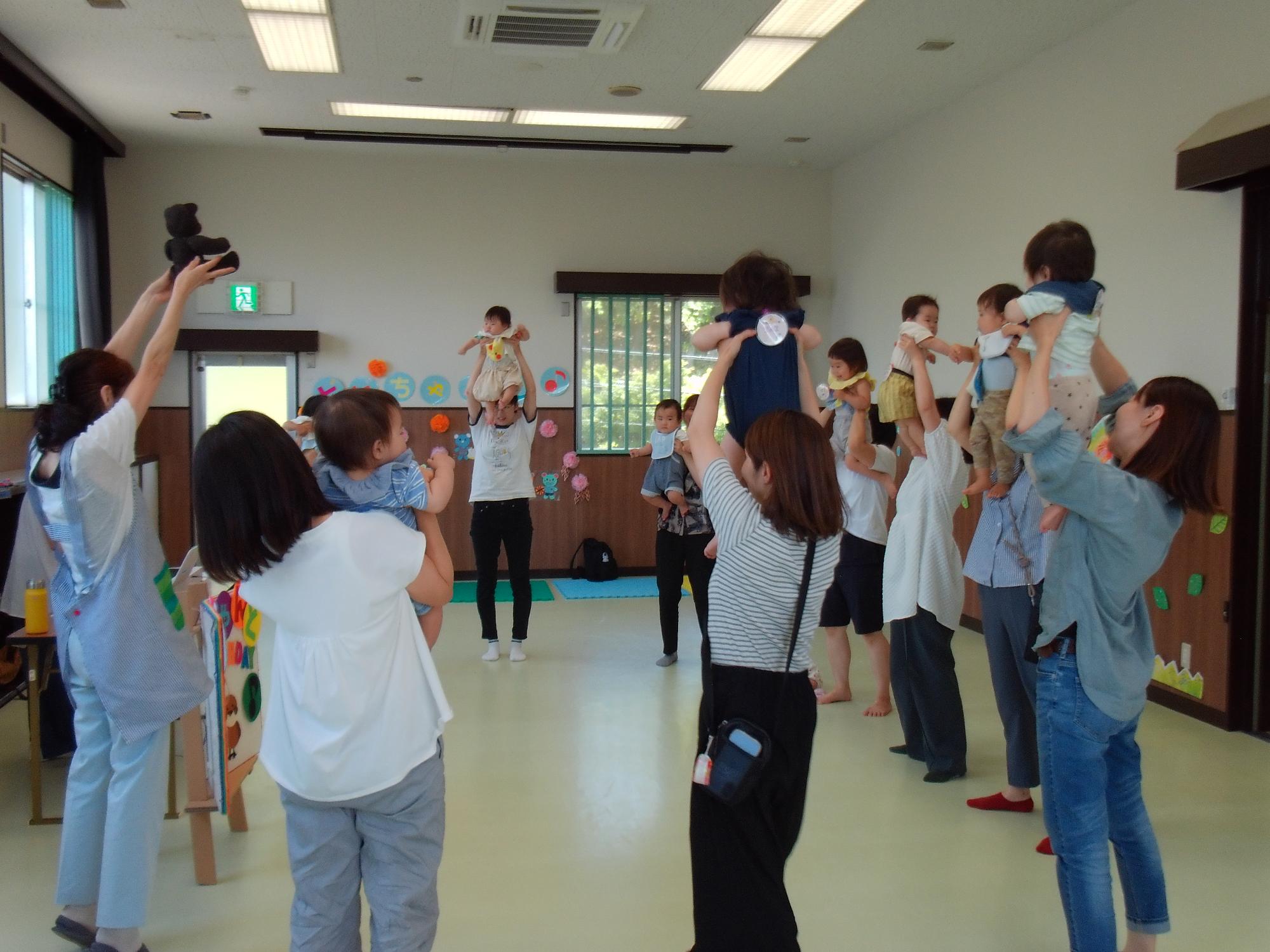 乳幼児親子がたかいたかいをしている写真