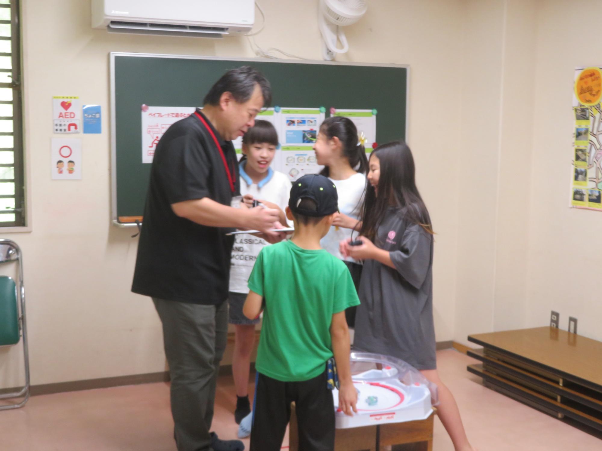 職員が子ども達に対戦結果を説明している写真