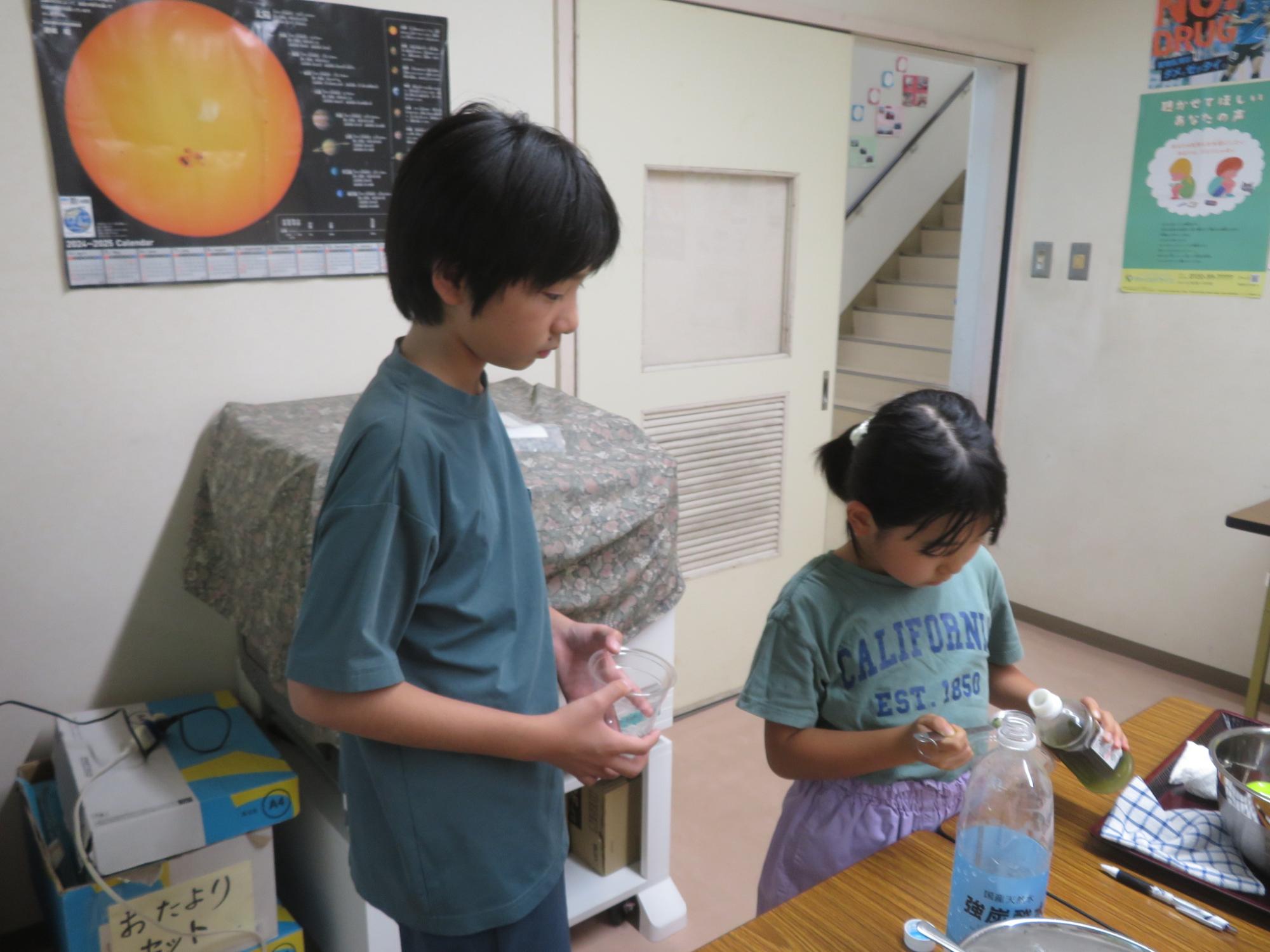 こどもがシロップを計量スプーンで計っている写真