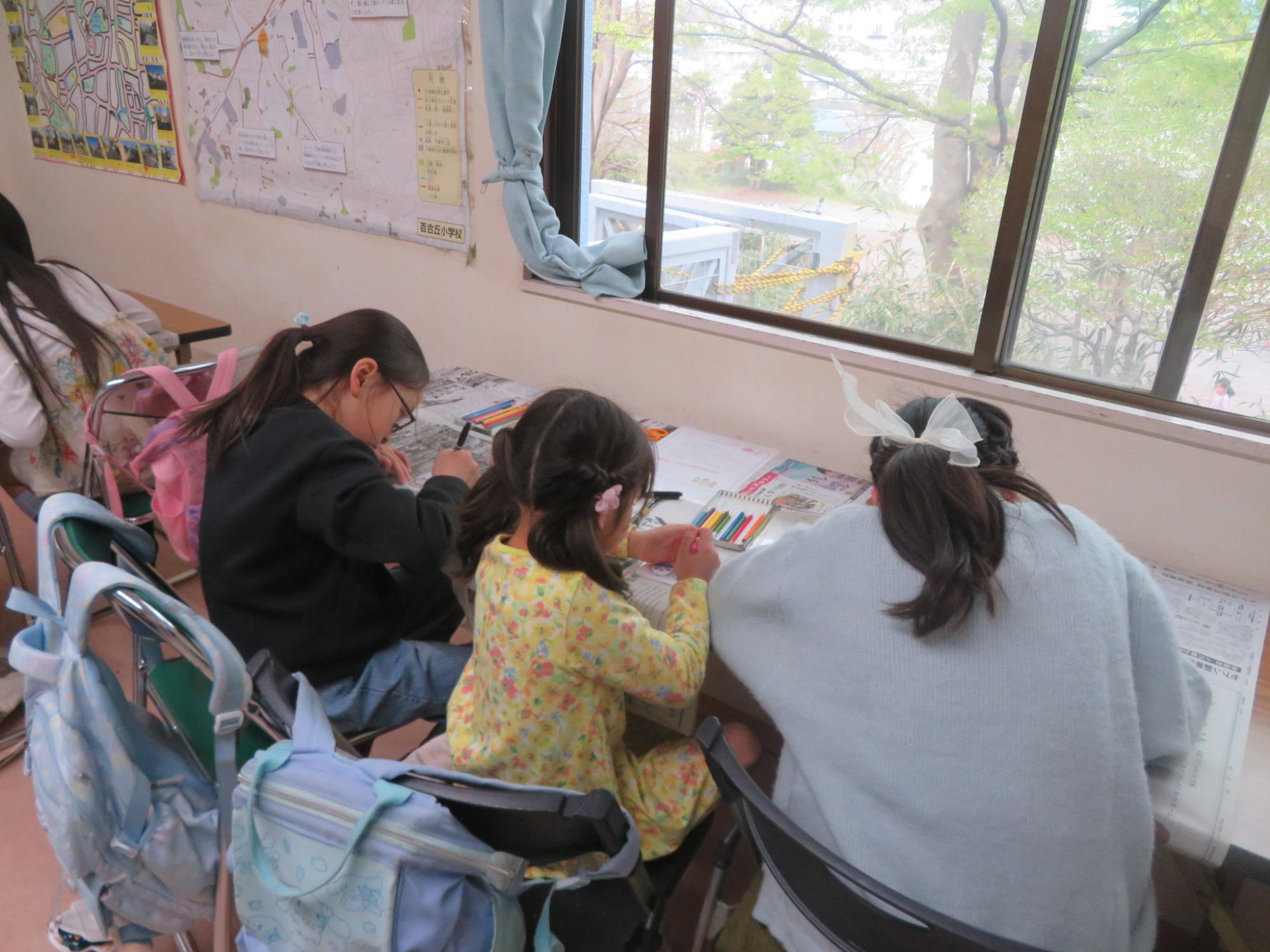 プラバンに絵をかいている小学生3人の写真