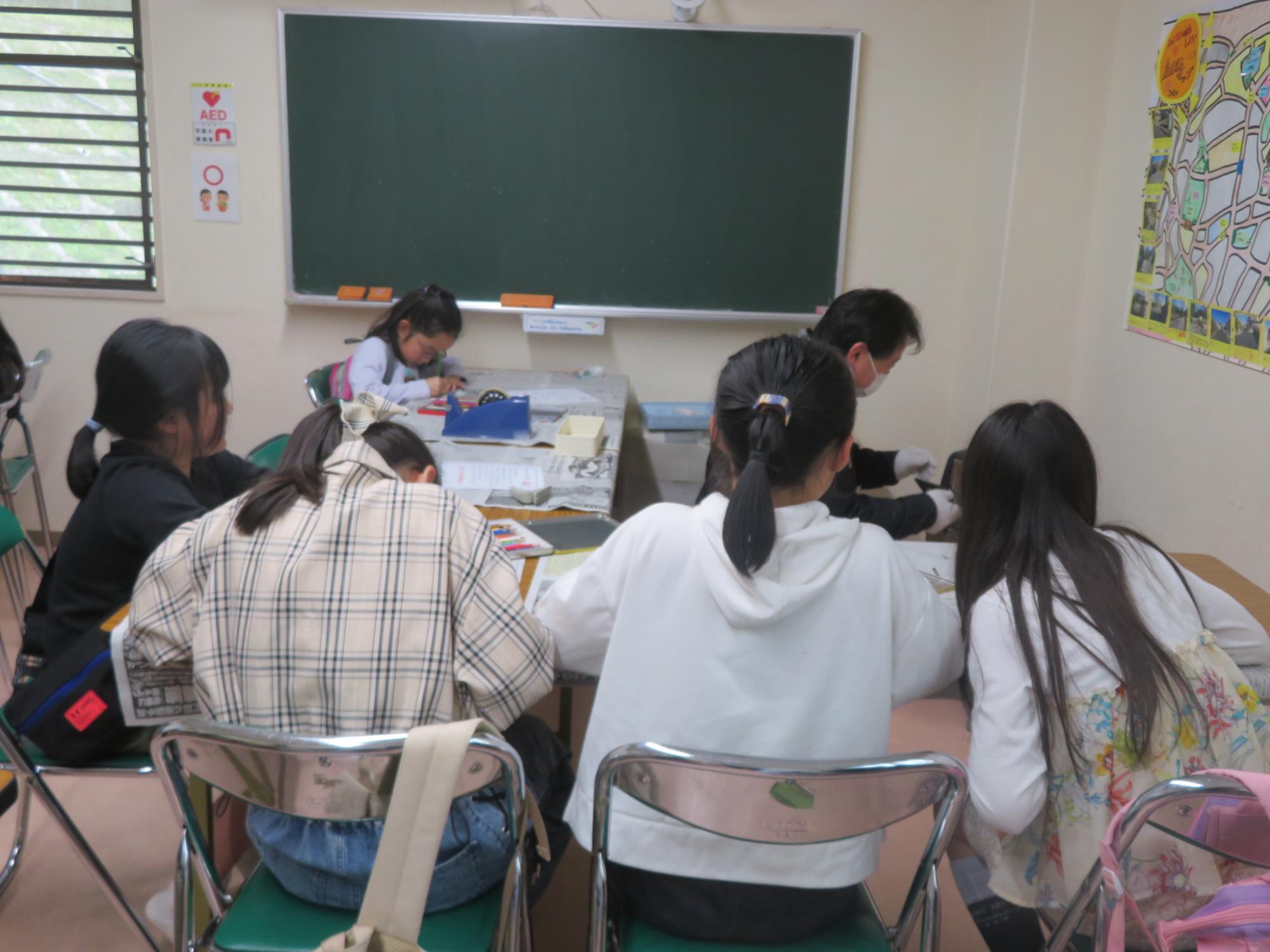 プラバンに絵をかいている小学生5人の写真