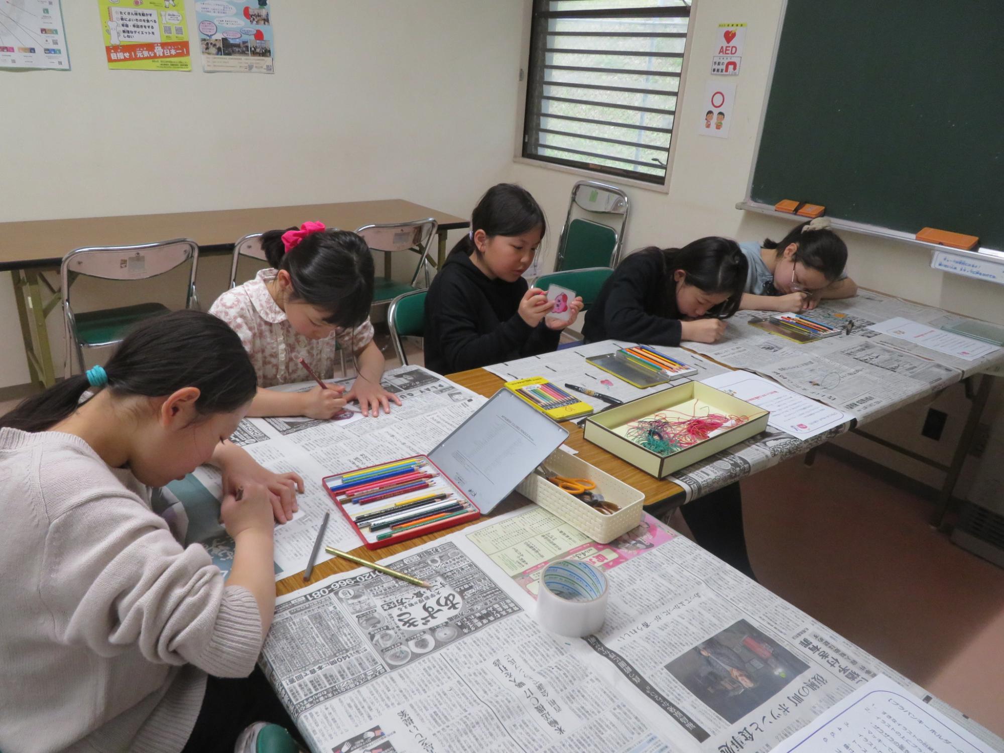 プラバンに絵をかいている小学生5人の写真