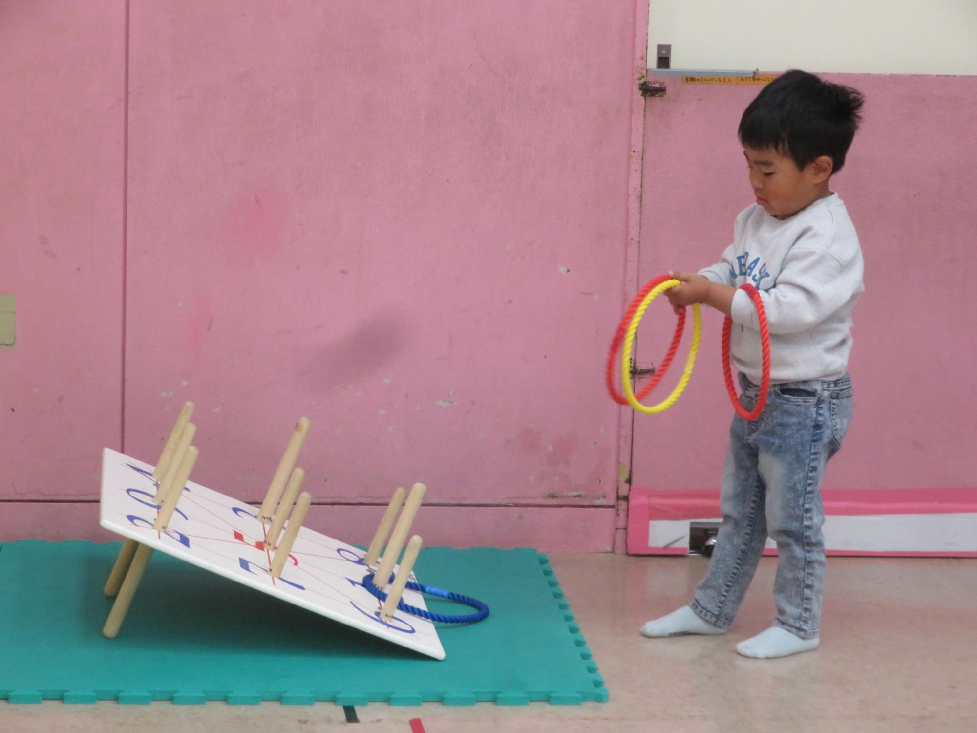 男の子がわなげで遊んでいる写真