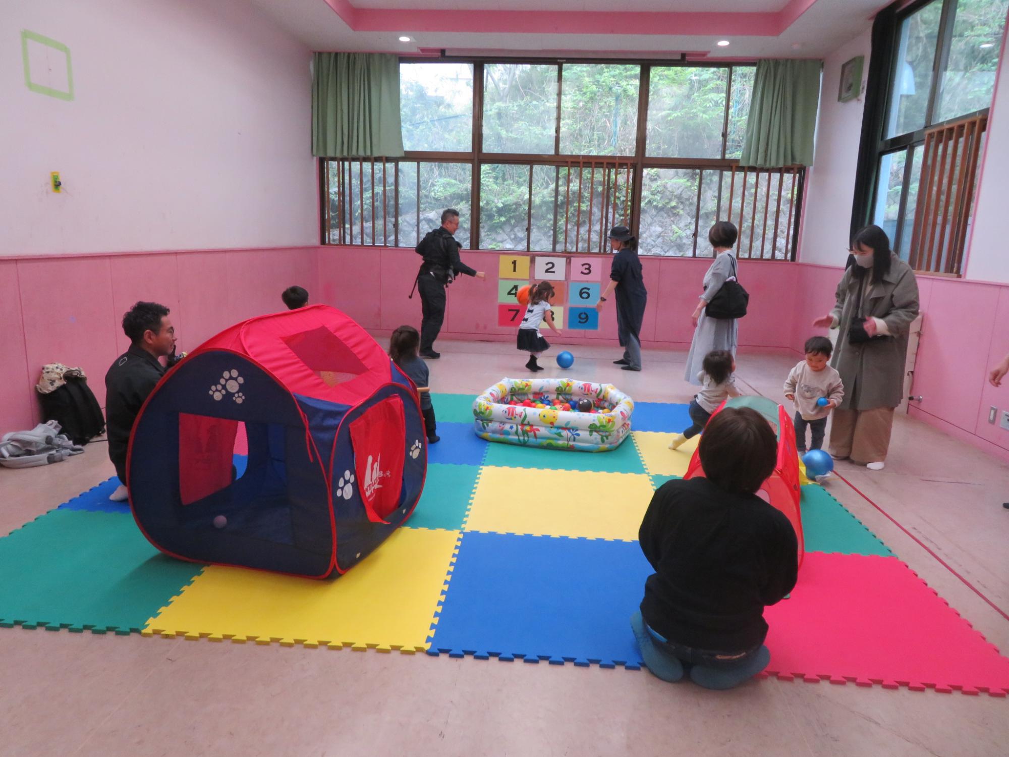 幼児親子が集会室に設置された遊具で遊んでいる写真