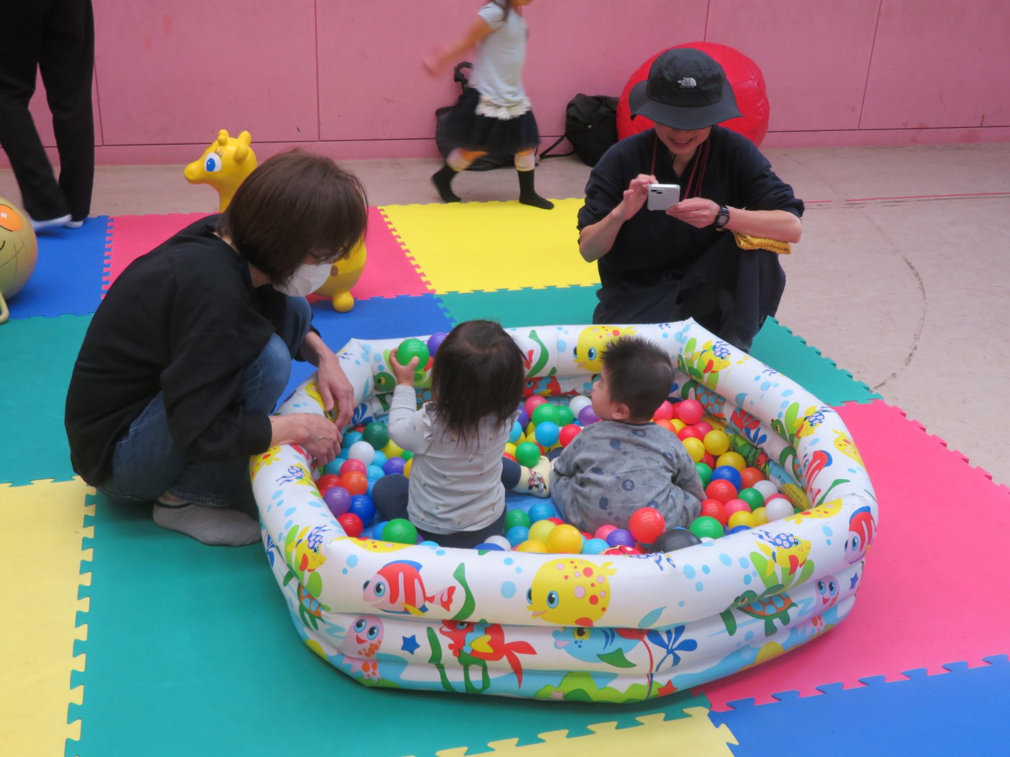 幼児親子がボールプールで遊んでいる写真