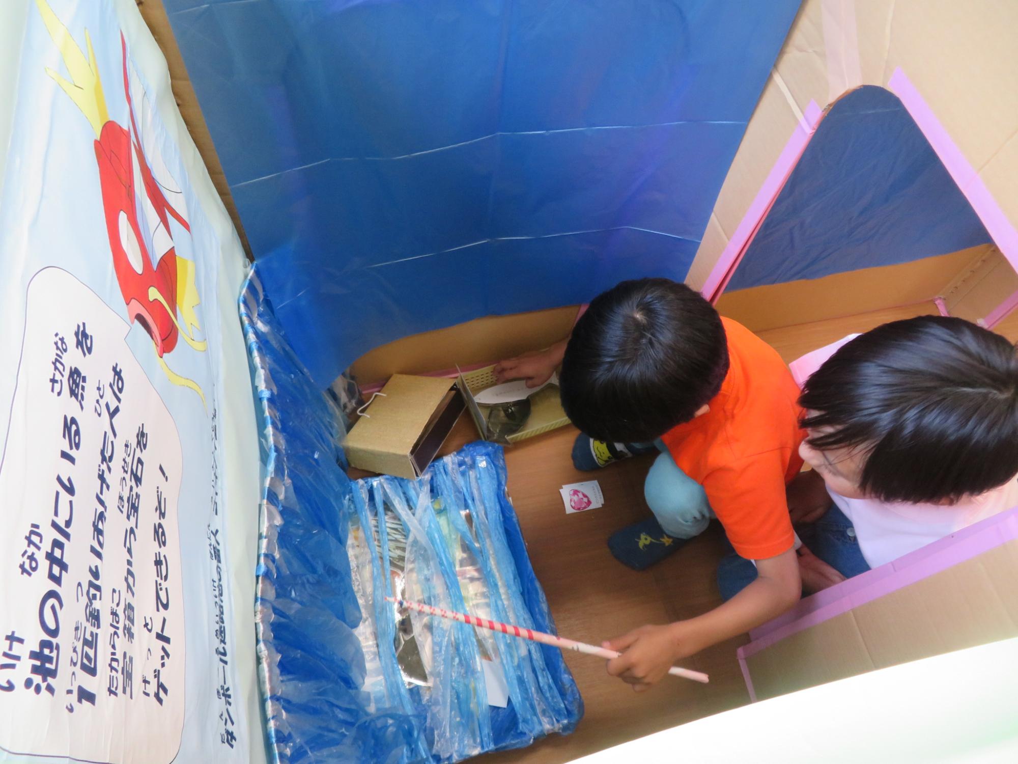ダンボール迷路内のコイキングがだすミッションで魚釣りをしている男の子たちの様子