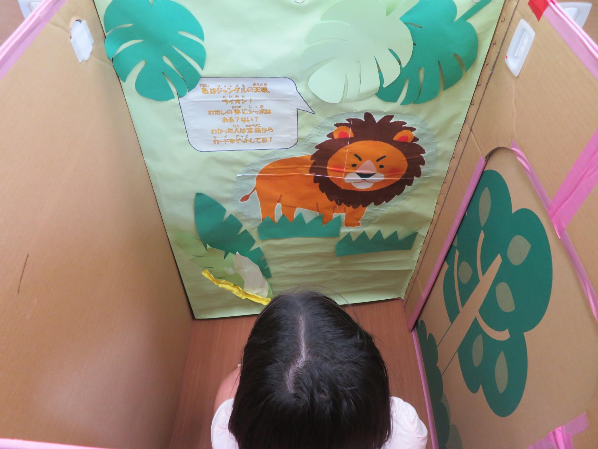 ダンボール迷路内のライオンがだすミッションを読んでいる女の子の様子
