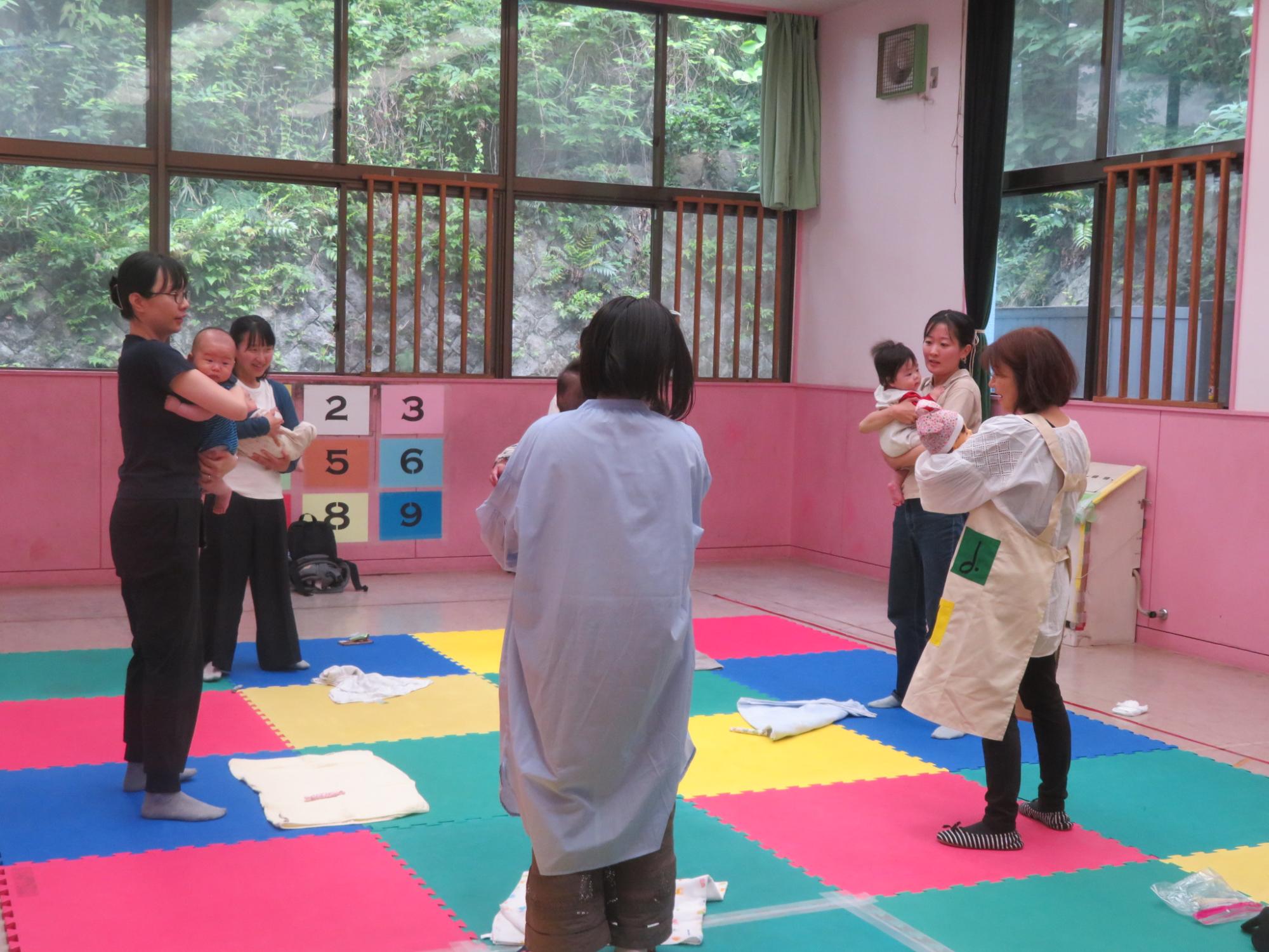 赤ちゃんを抱いている親子と講師の様子