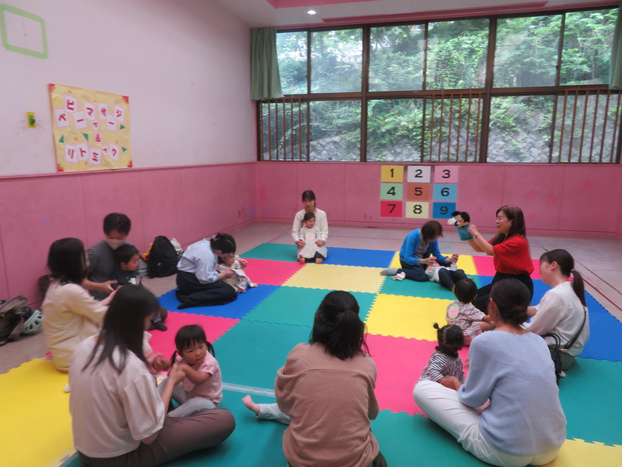 輪になって座り、講師の話を聞く親子の様子