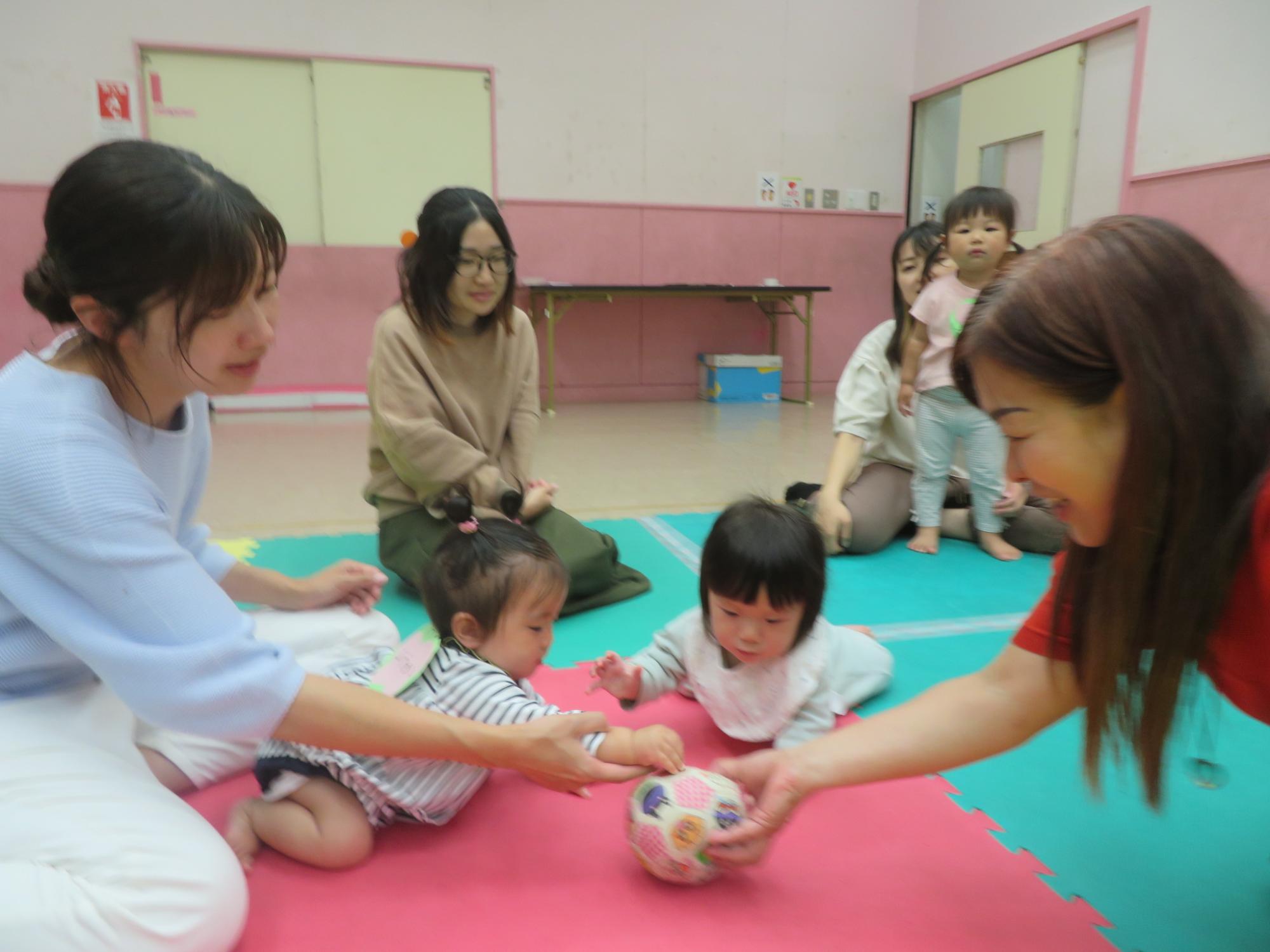 講師が出すボールをつかもうとする二人の子ども様子