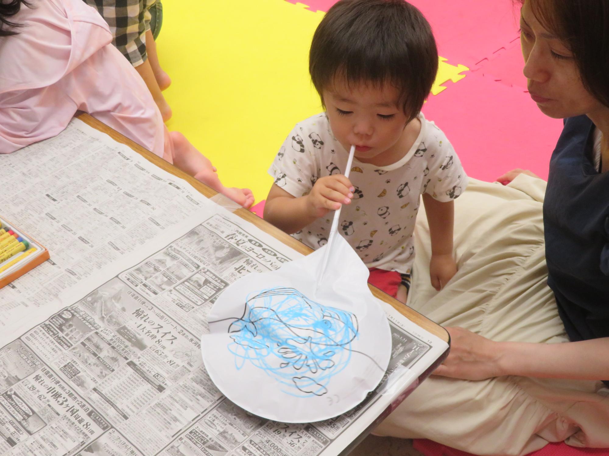 男の子が工作用風船を膨らませている様子