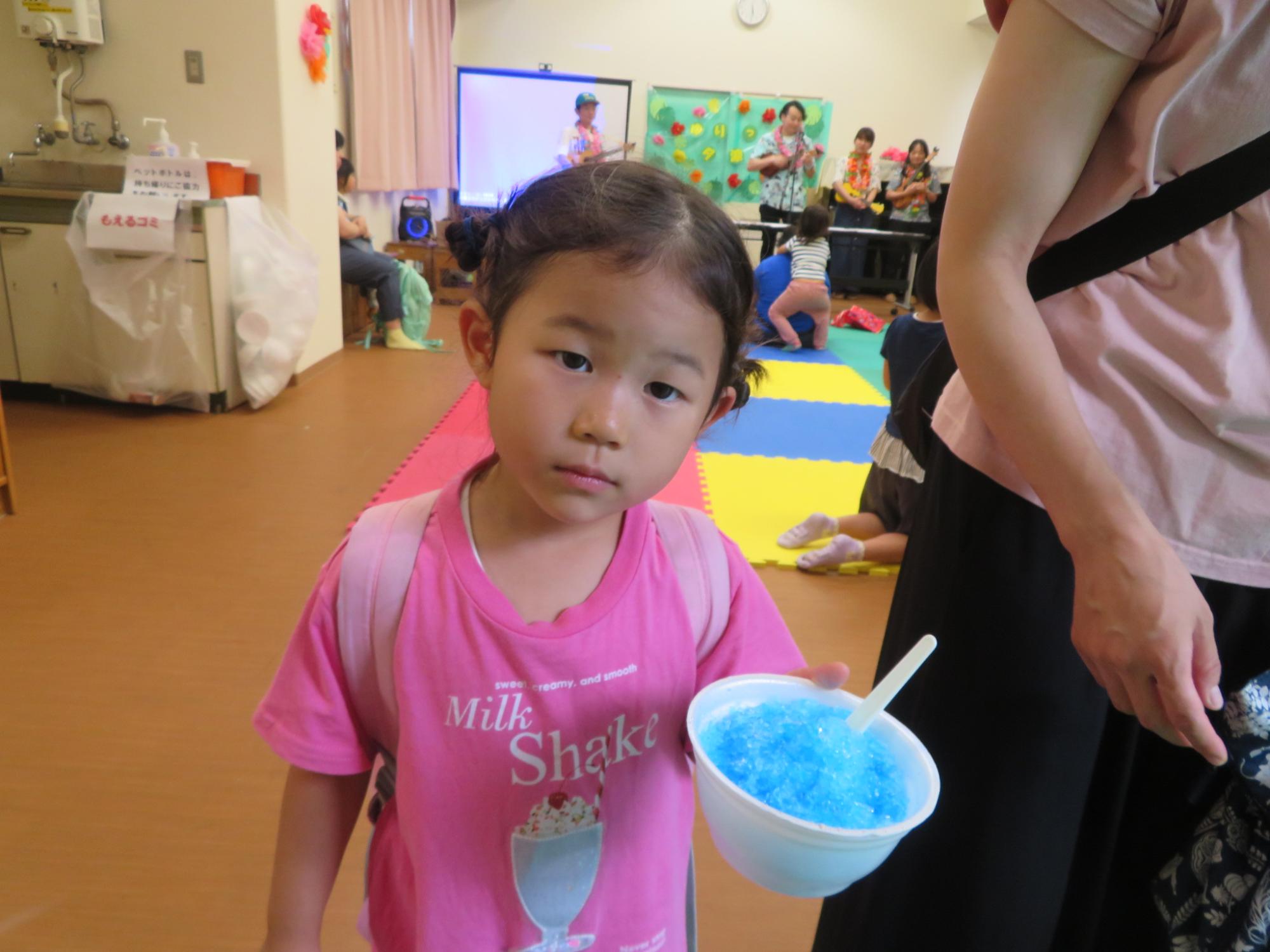 ブルーハワイ味のかき氷を持ってポーズしている児童の写真