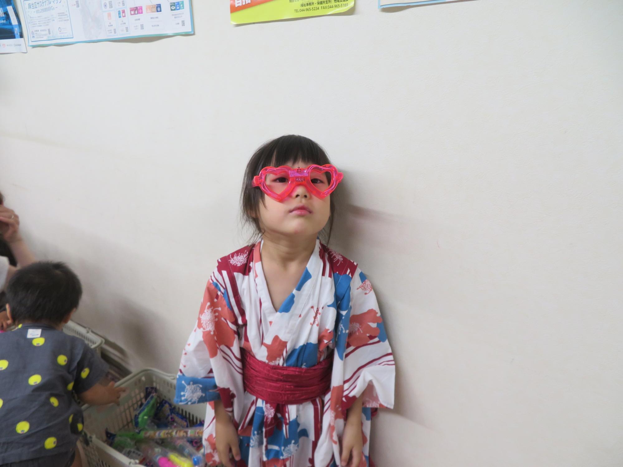 ゆりっこ夕涼みの射的コーナー景品だった光るメガねをしている幼児の写真