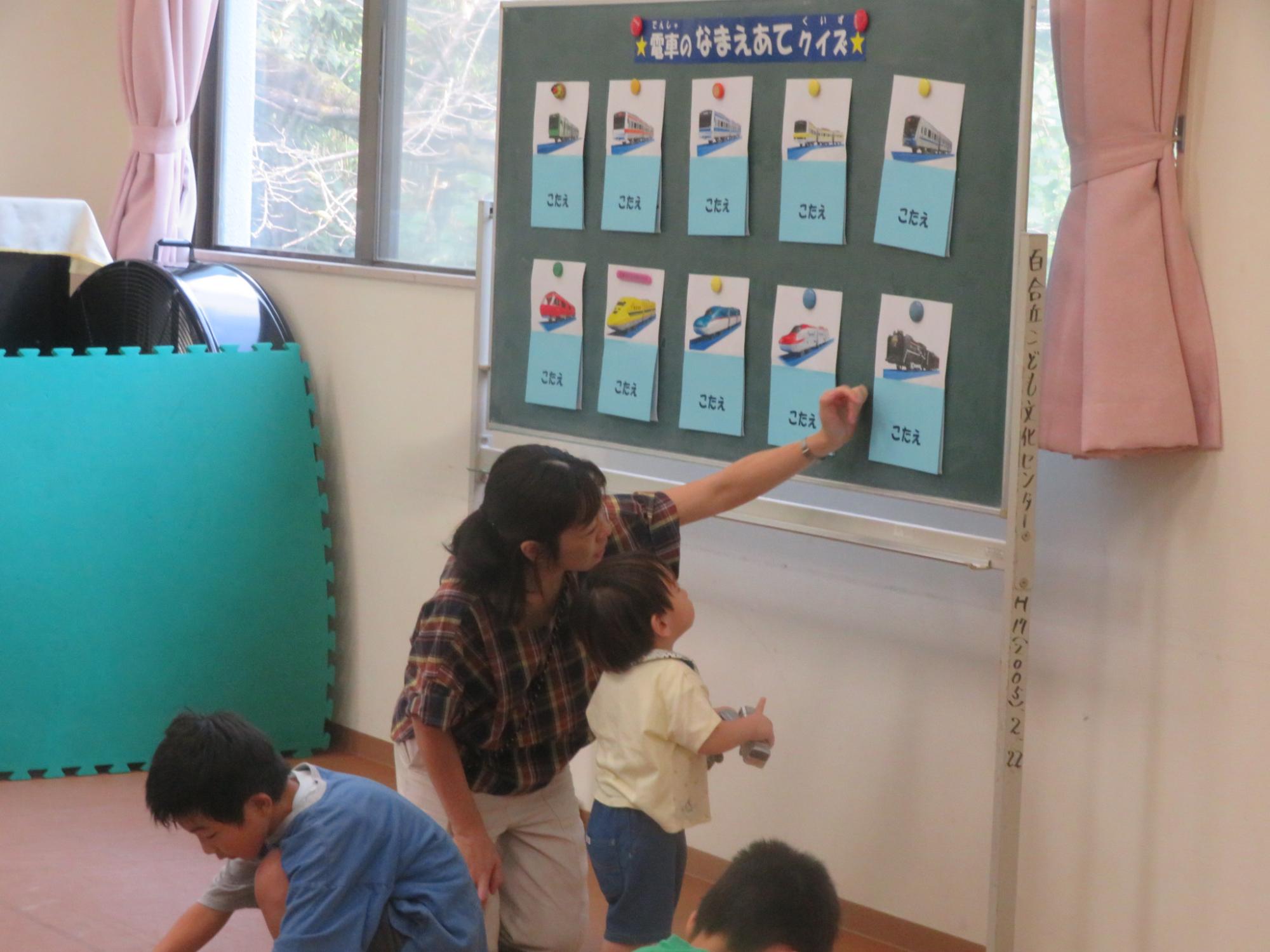 電車の名前当てクイズを楽しむ幼児親子の写真