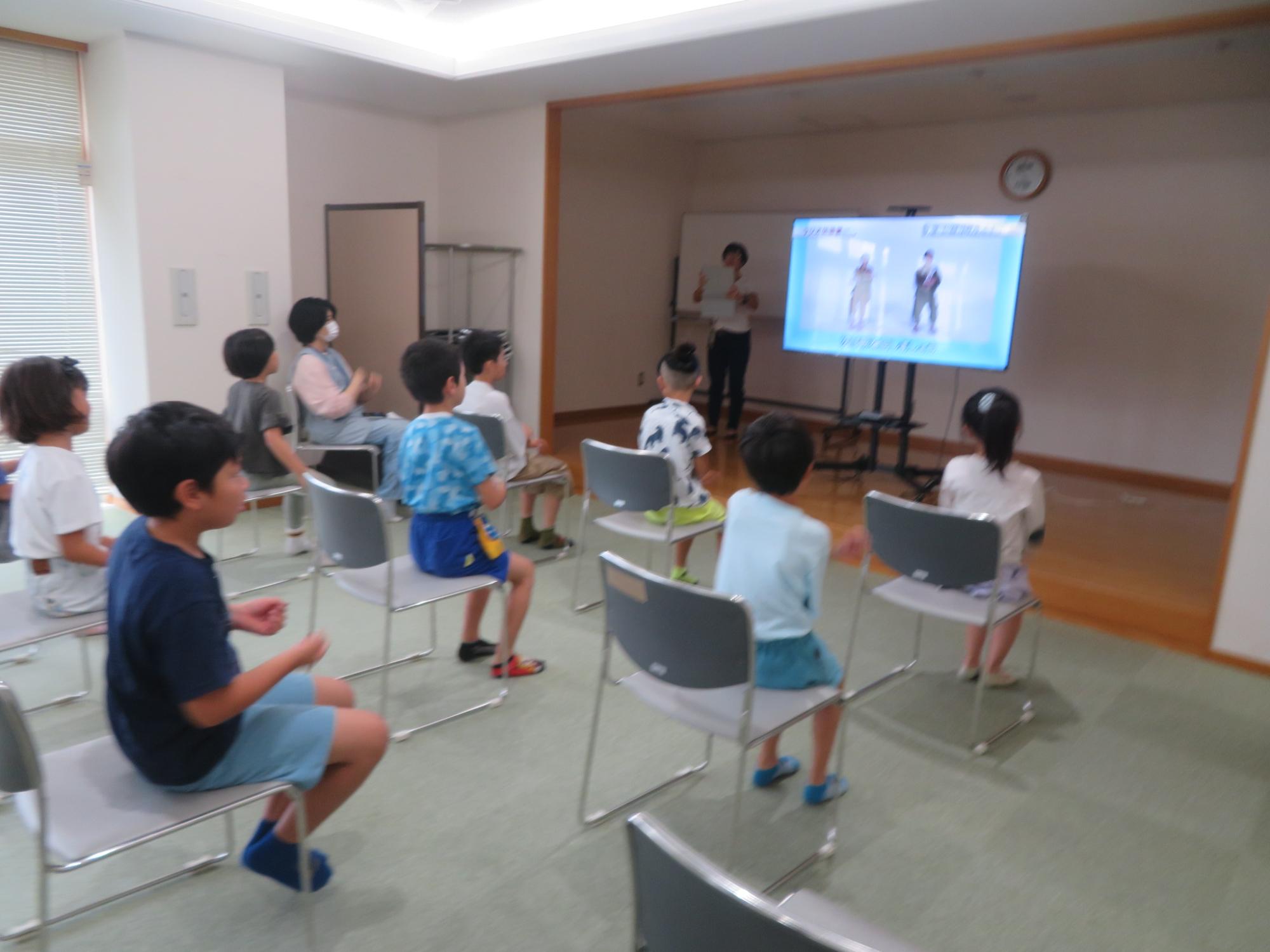 工作材料を乾かしている間に、いこいの家の人と体操をしている様子