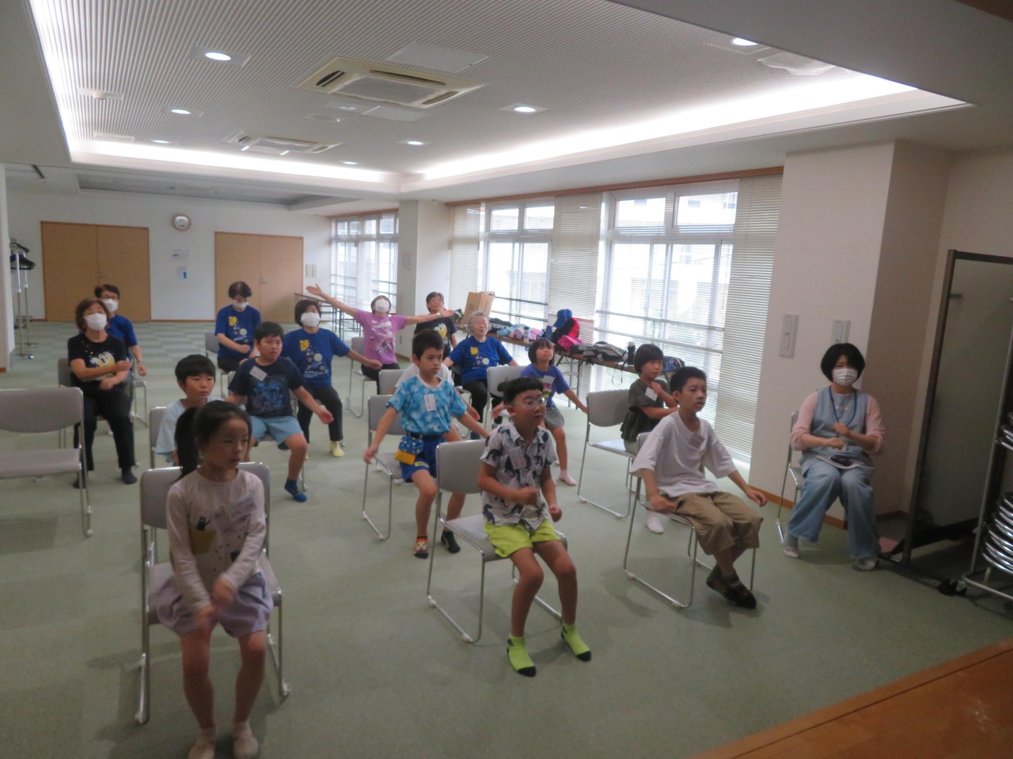 工作材料を乾かしている間に、いこいの家の人と体操をしている様子