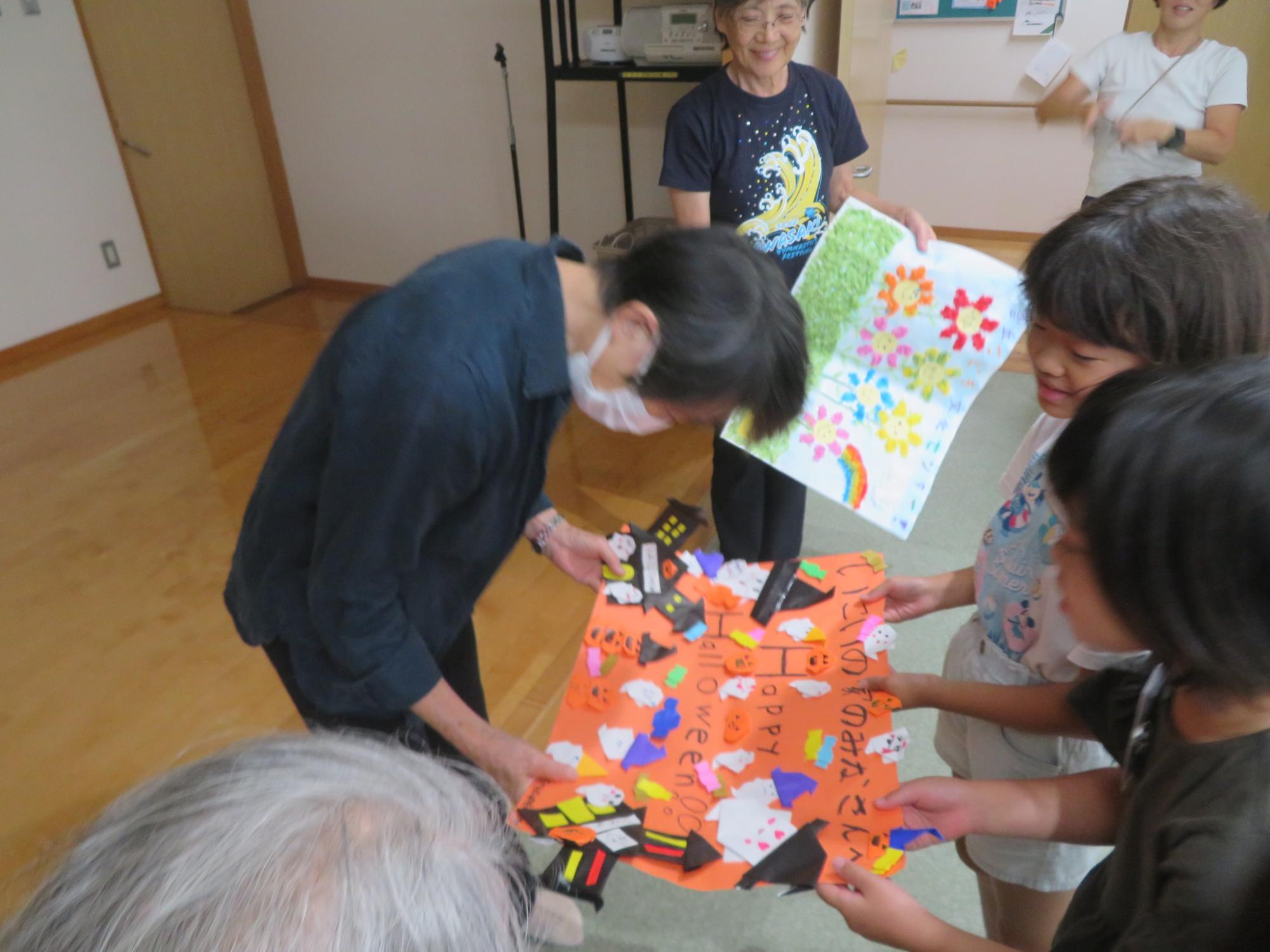 児童たちが、いこいの家の方たちにプレゼントしている写真