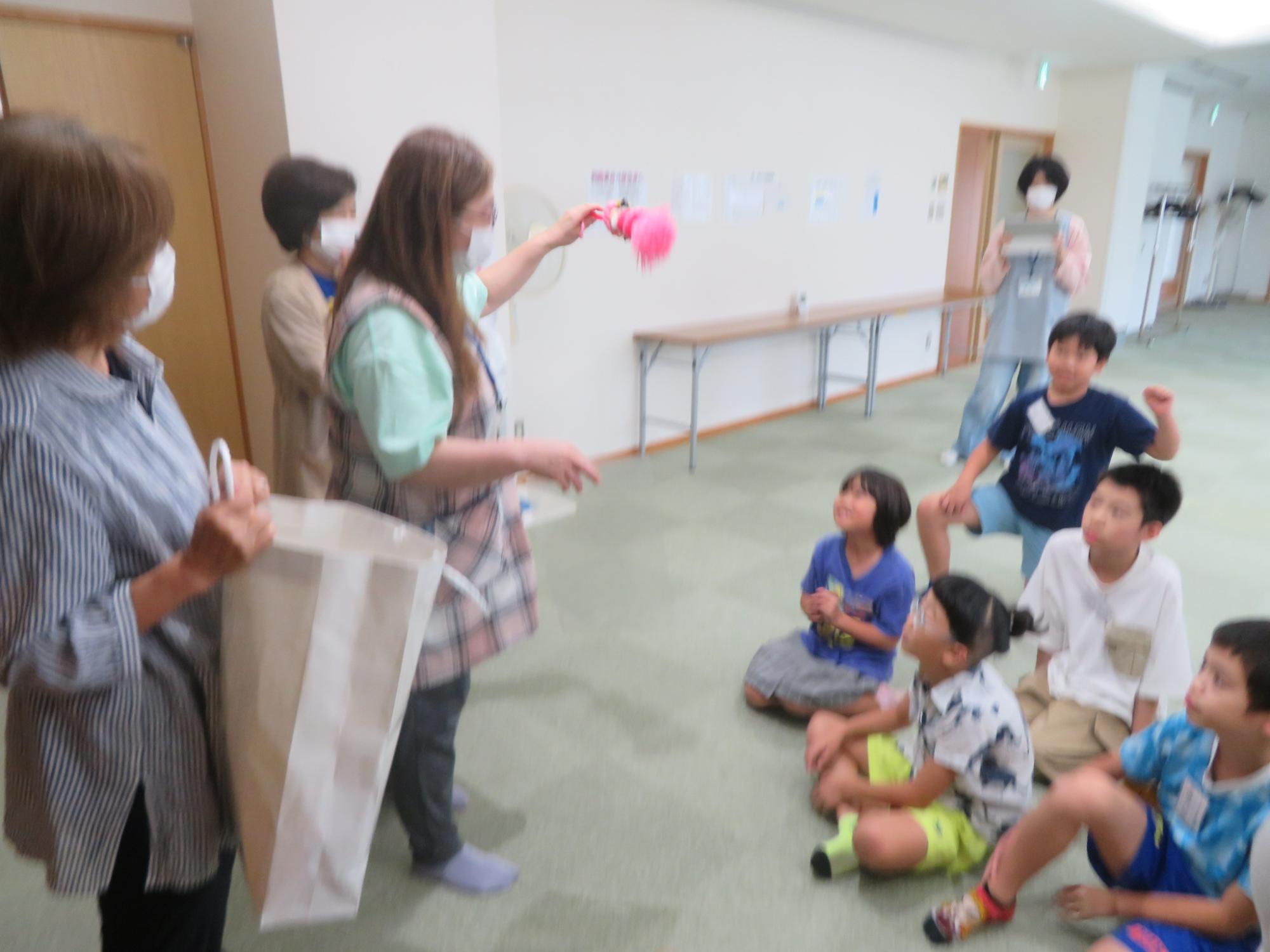 いこいの家の方たちが児童たちにプレゼントを渡している写真