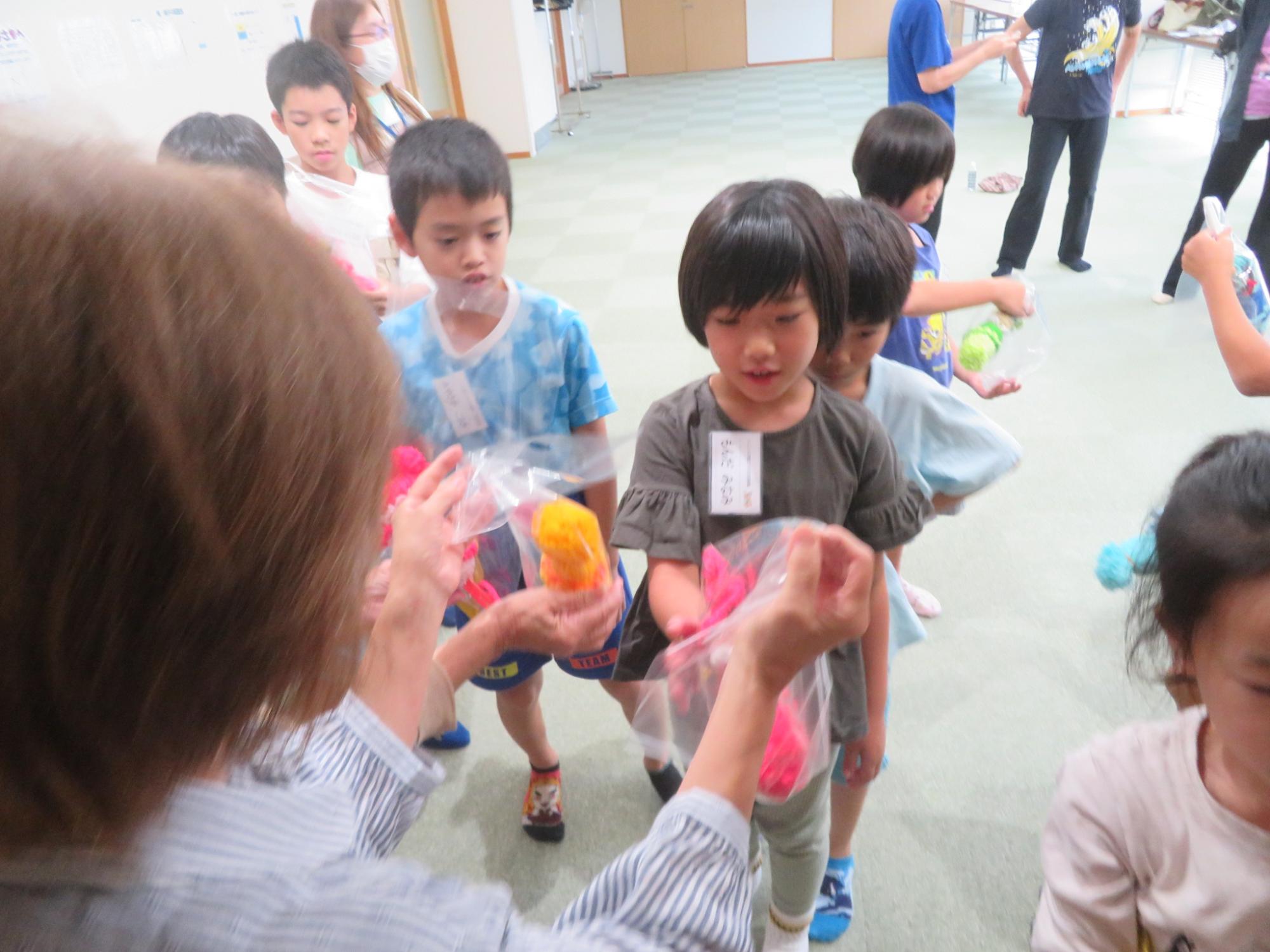 いこいの家の方たちが児童たちにプレゼントを渡している写真