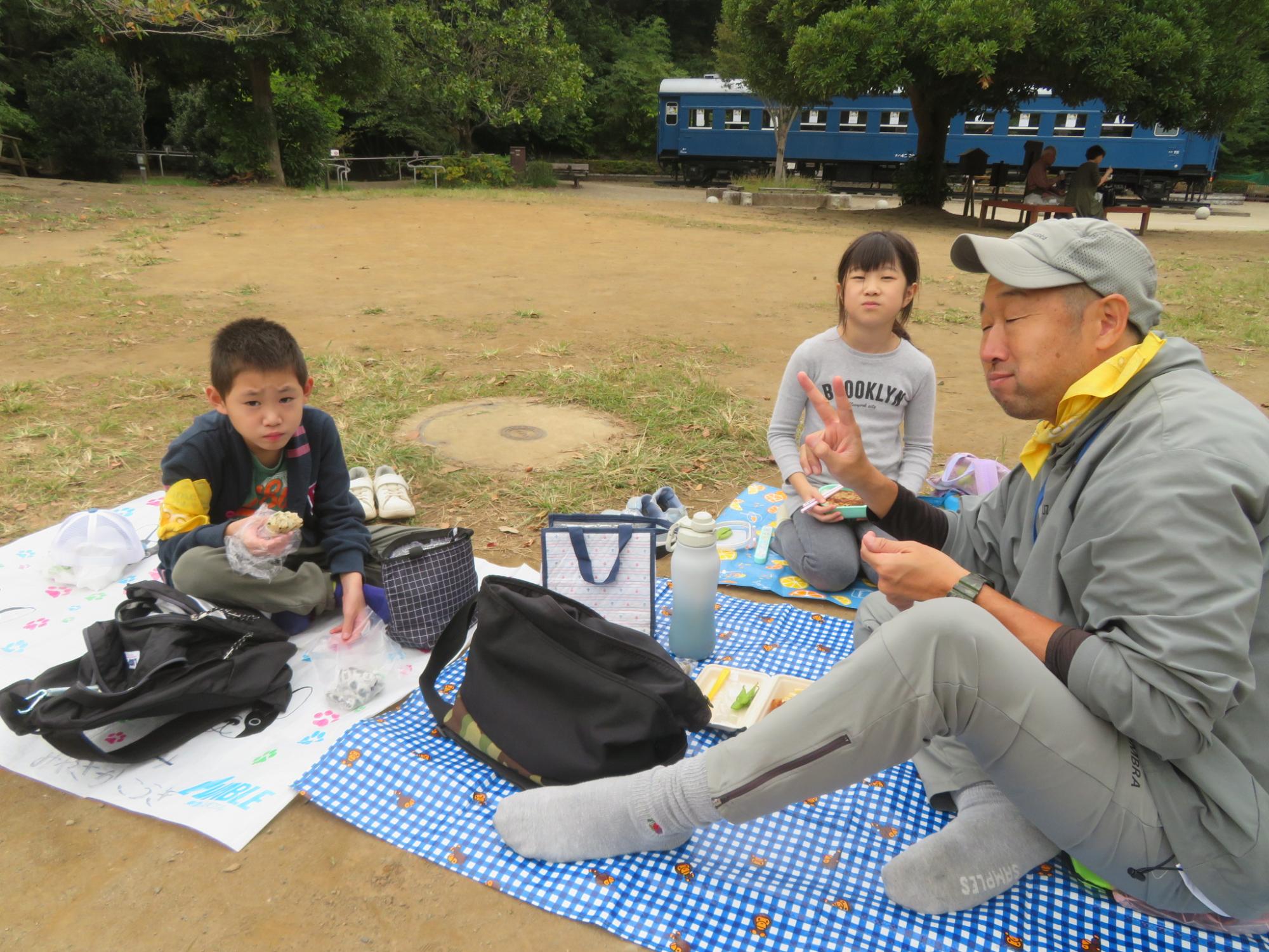 お弁当を食べている児童と館長の写真