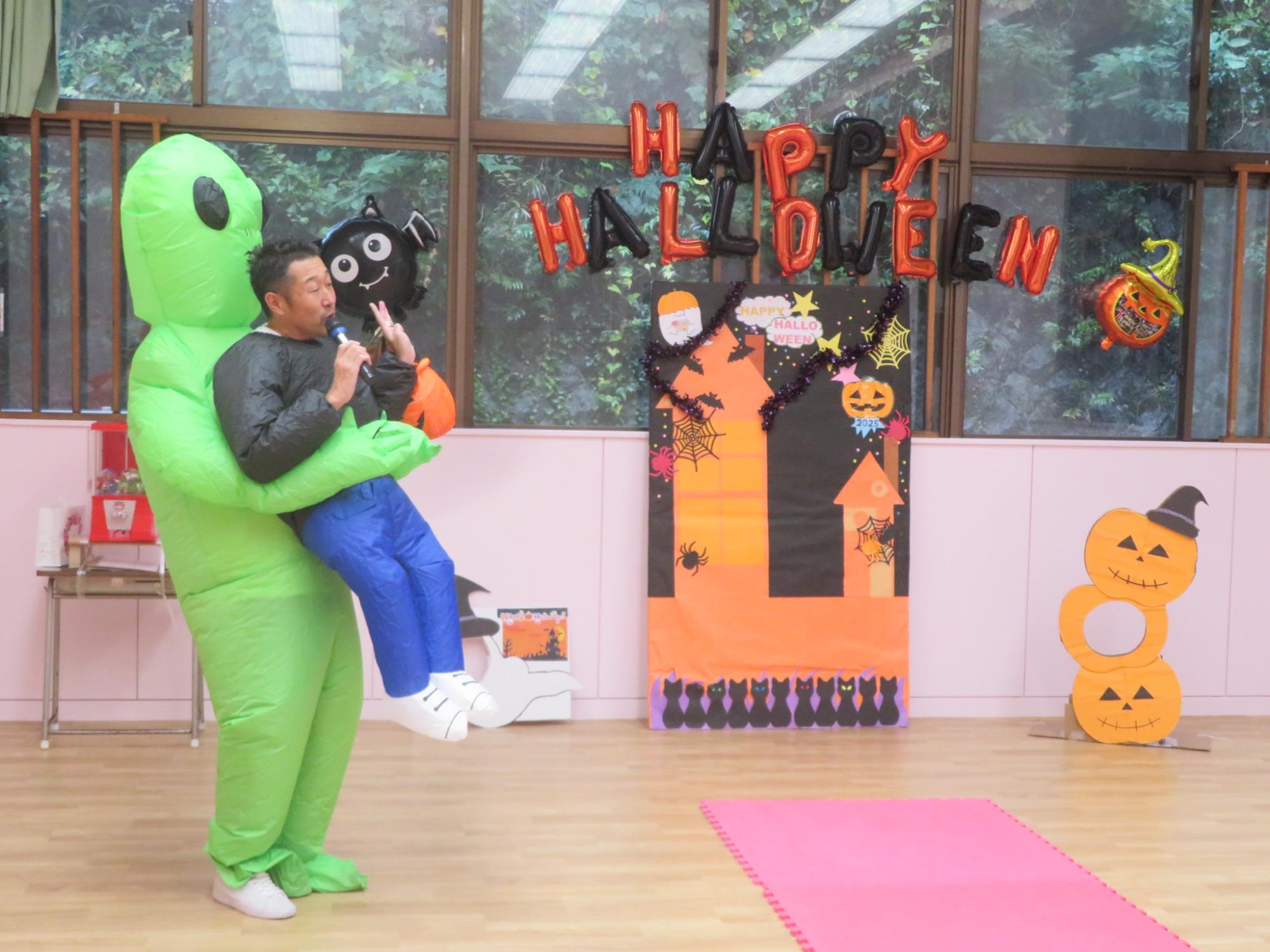 宇宙人の仮装をした館長が司会をしている様子