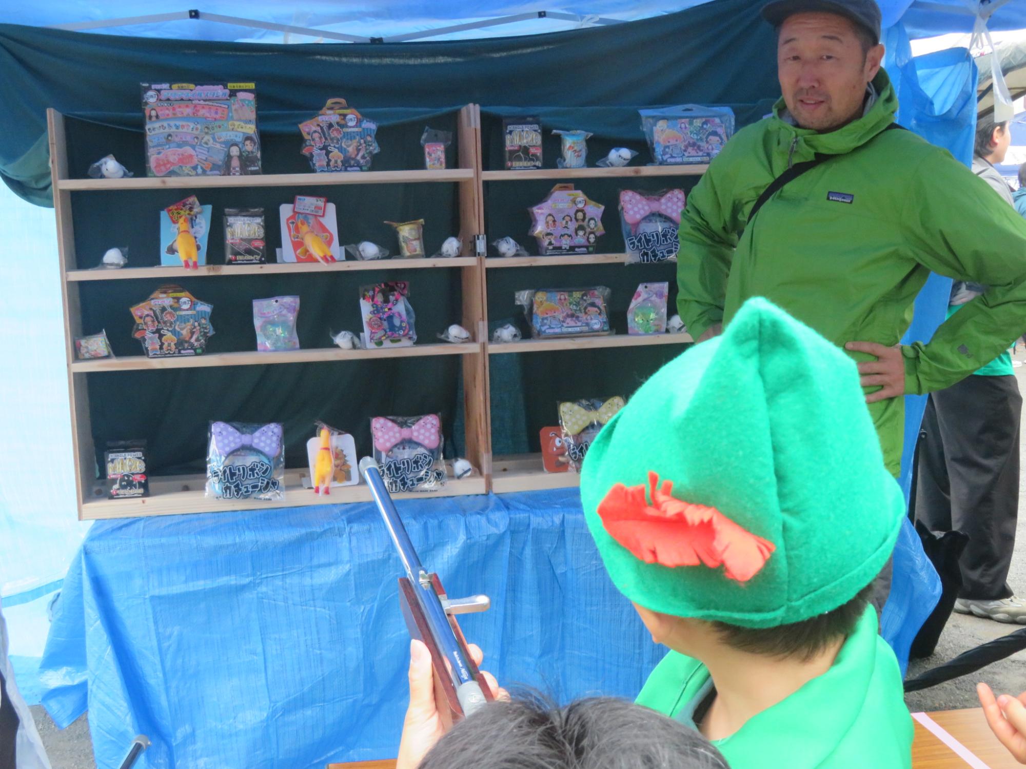 射的の銃をもって景品をねらう児童の写真