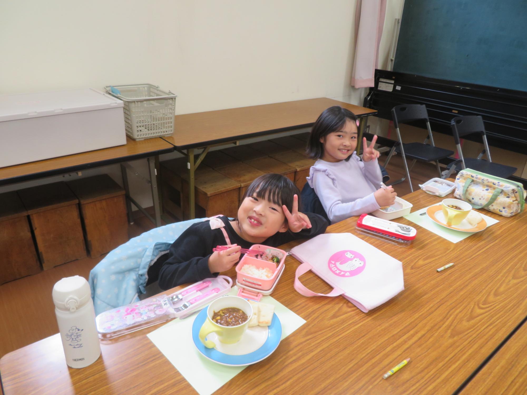 女の子2人がカレーを食べている写真