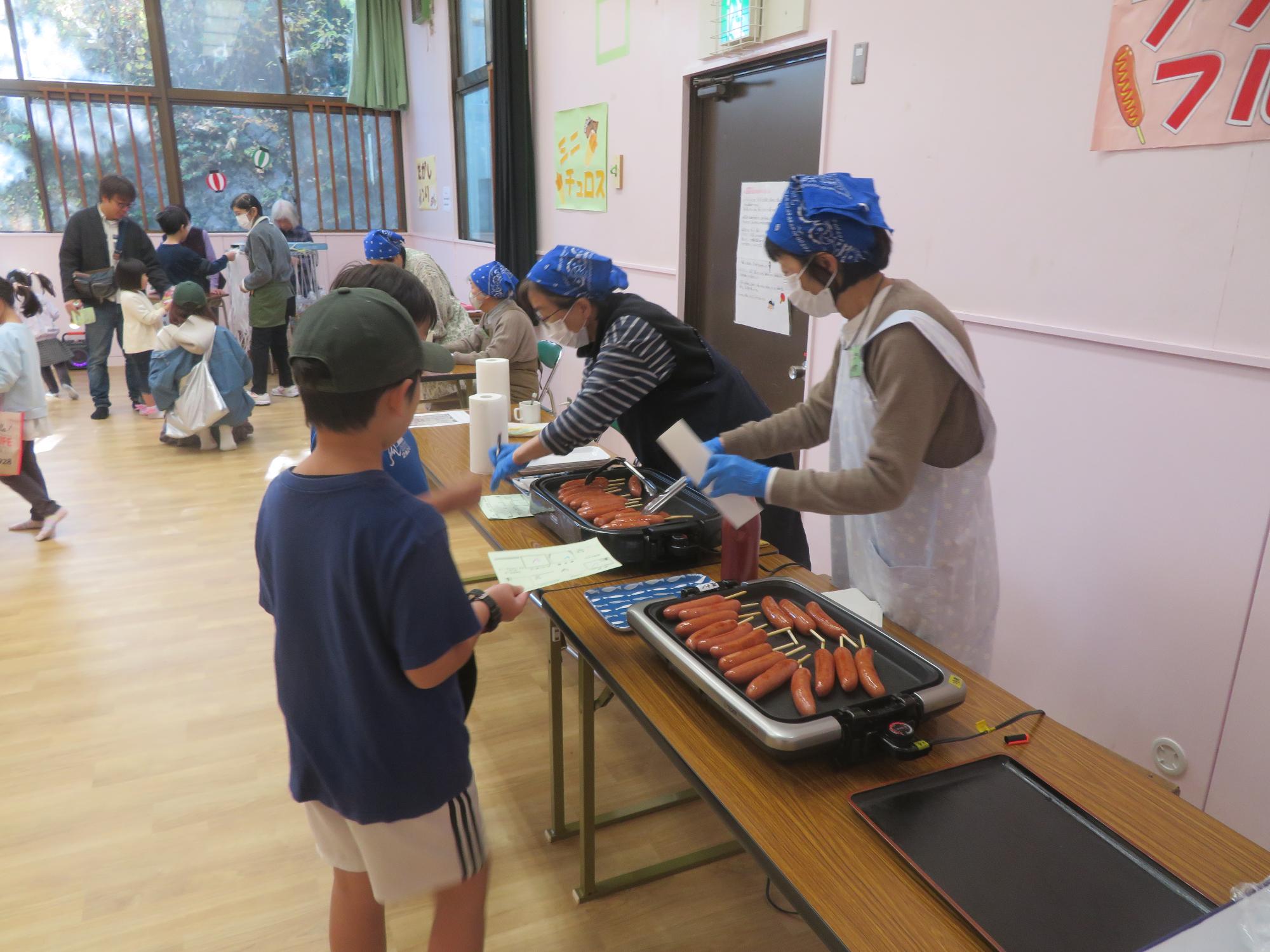 フランクフルトコーナーで男の子たちがフランクフルトを受け取っている写真