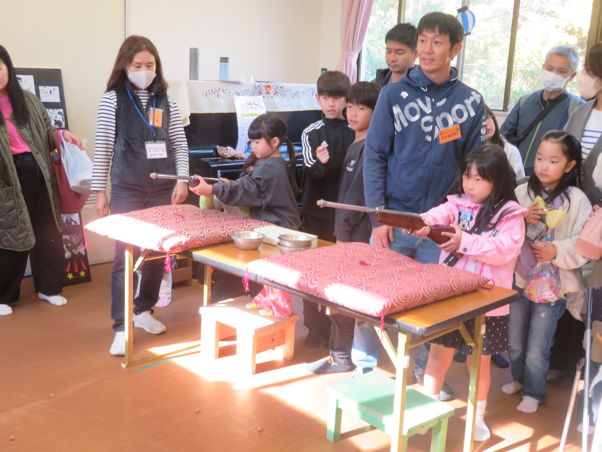 女の子2人が射的を楽しんでいる写真