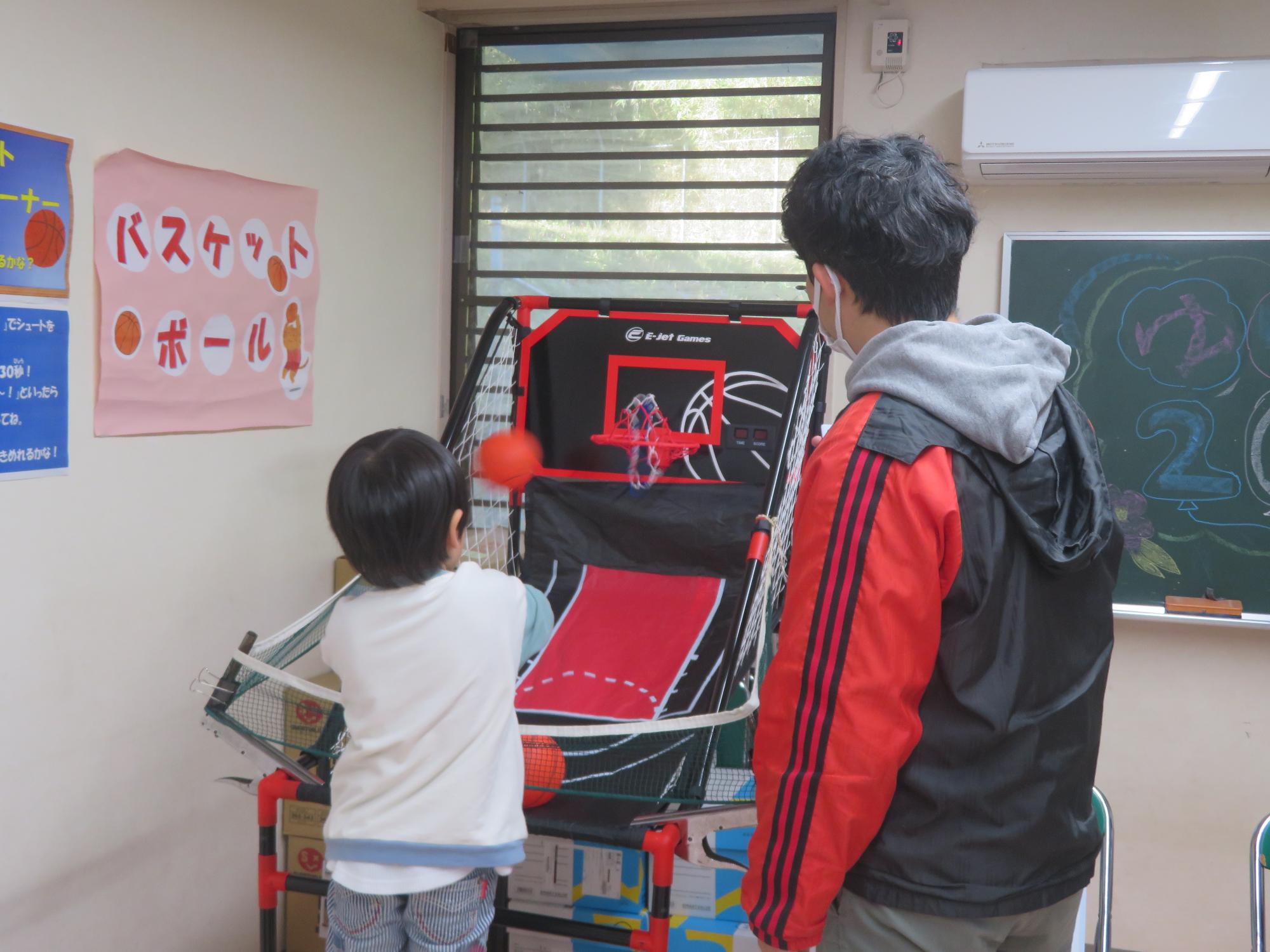 こどもゲームコーナでバスケットを楽しんでいる子どもたちの写真