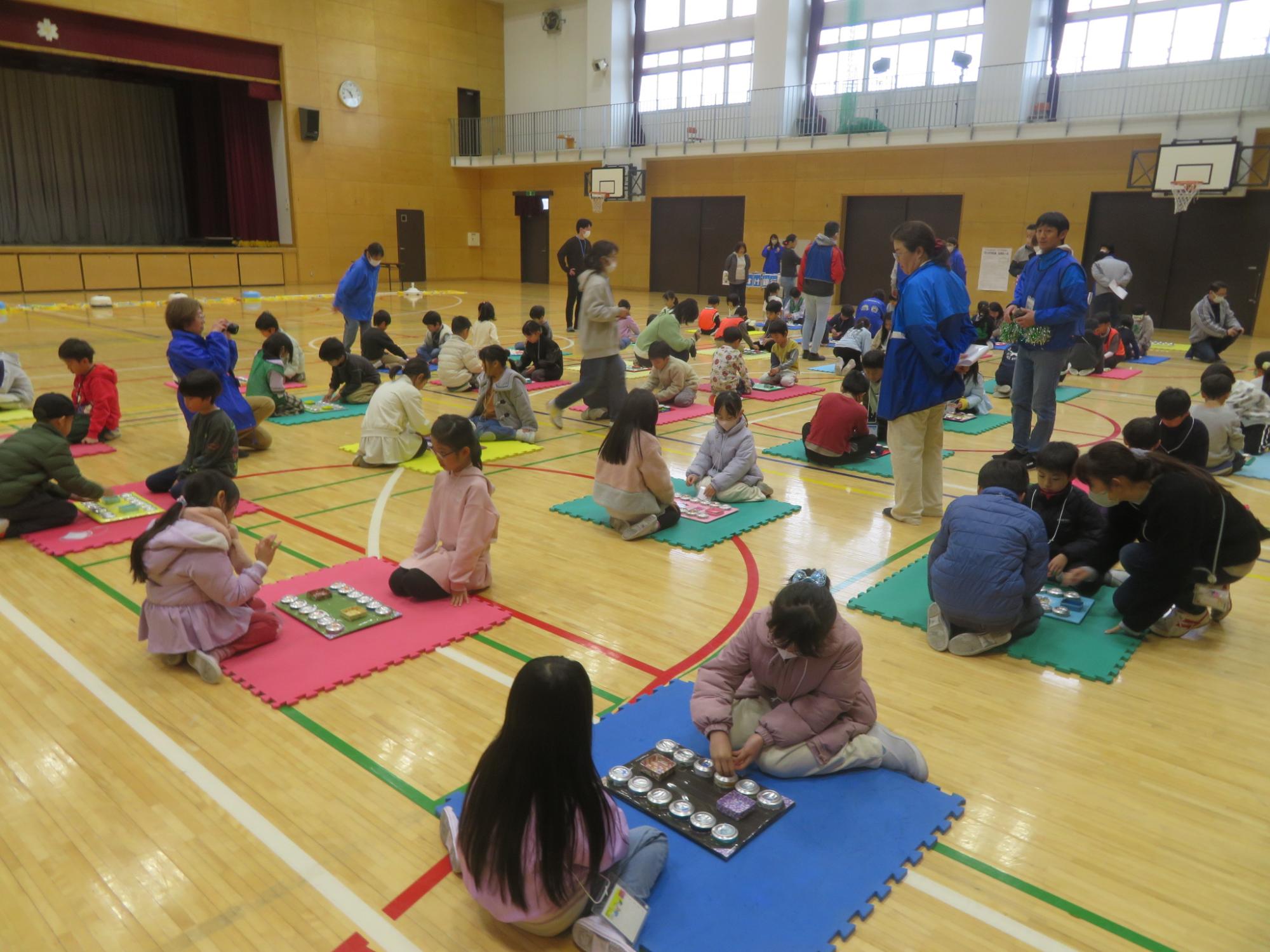 大勢でマンカラ大会に参加している児童の写真